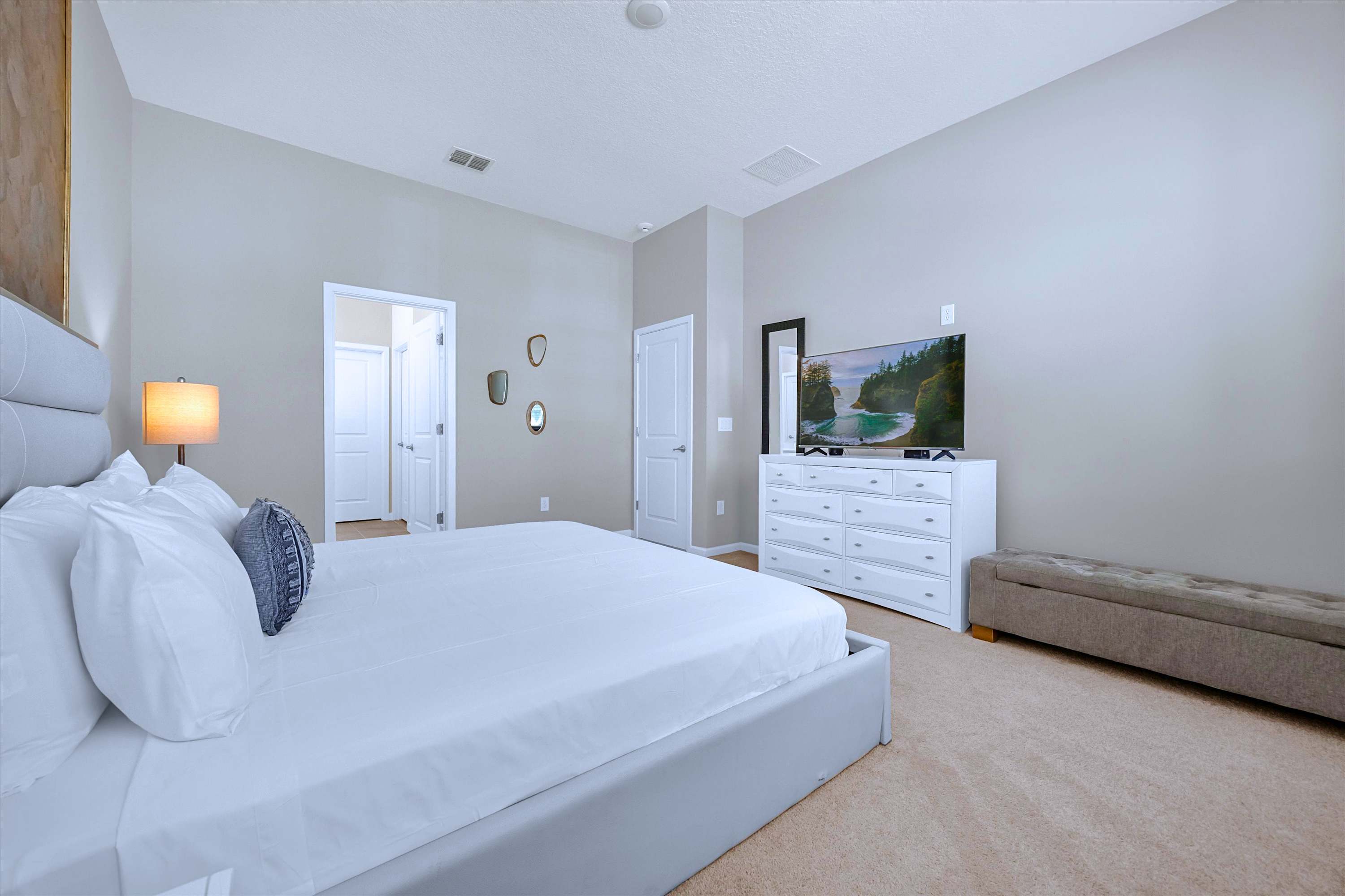 King Size Bed master suite with wall-mounted TV, vanity mirror, and bedroom bench
