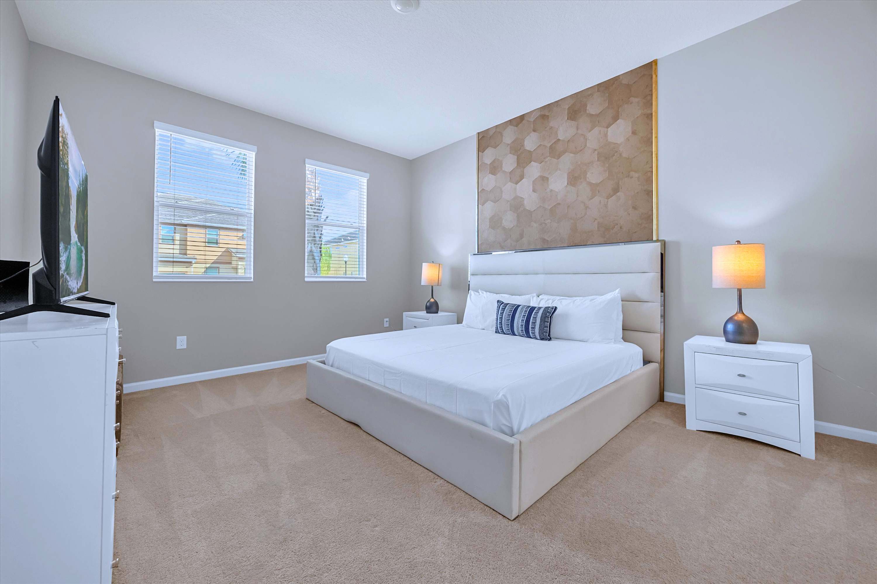 Relax in bed: plush King setup with ambient bedside lighting and a private TV for movie nights.