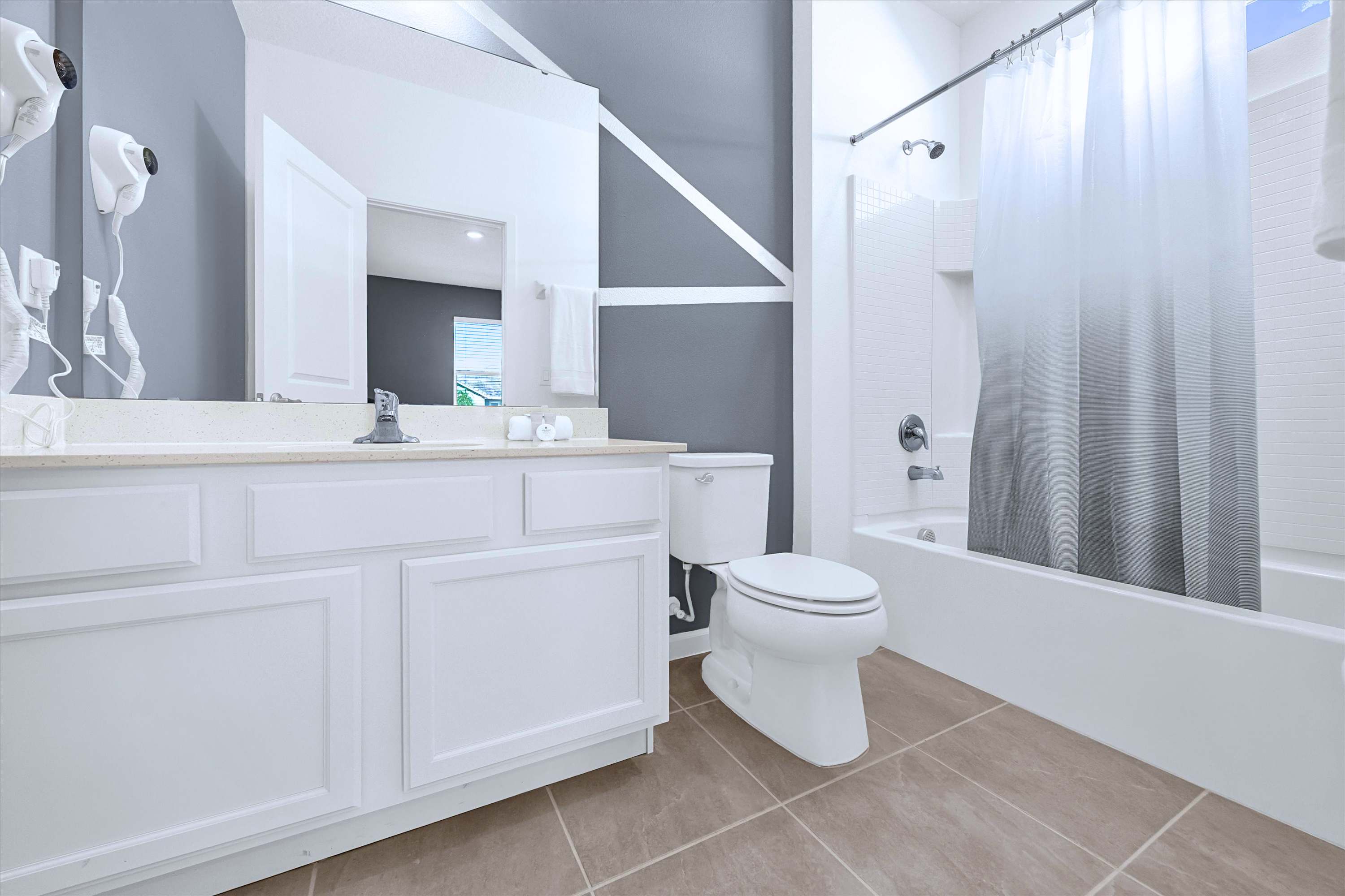 En-suite full bathroom featuring a sink vanity, mirror, toilet & shower-tub combo
