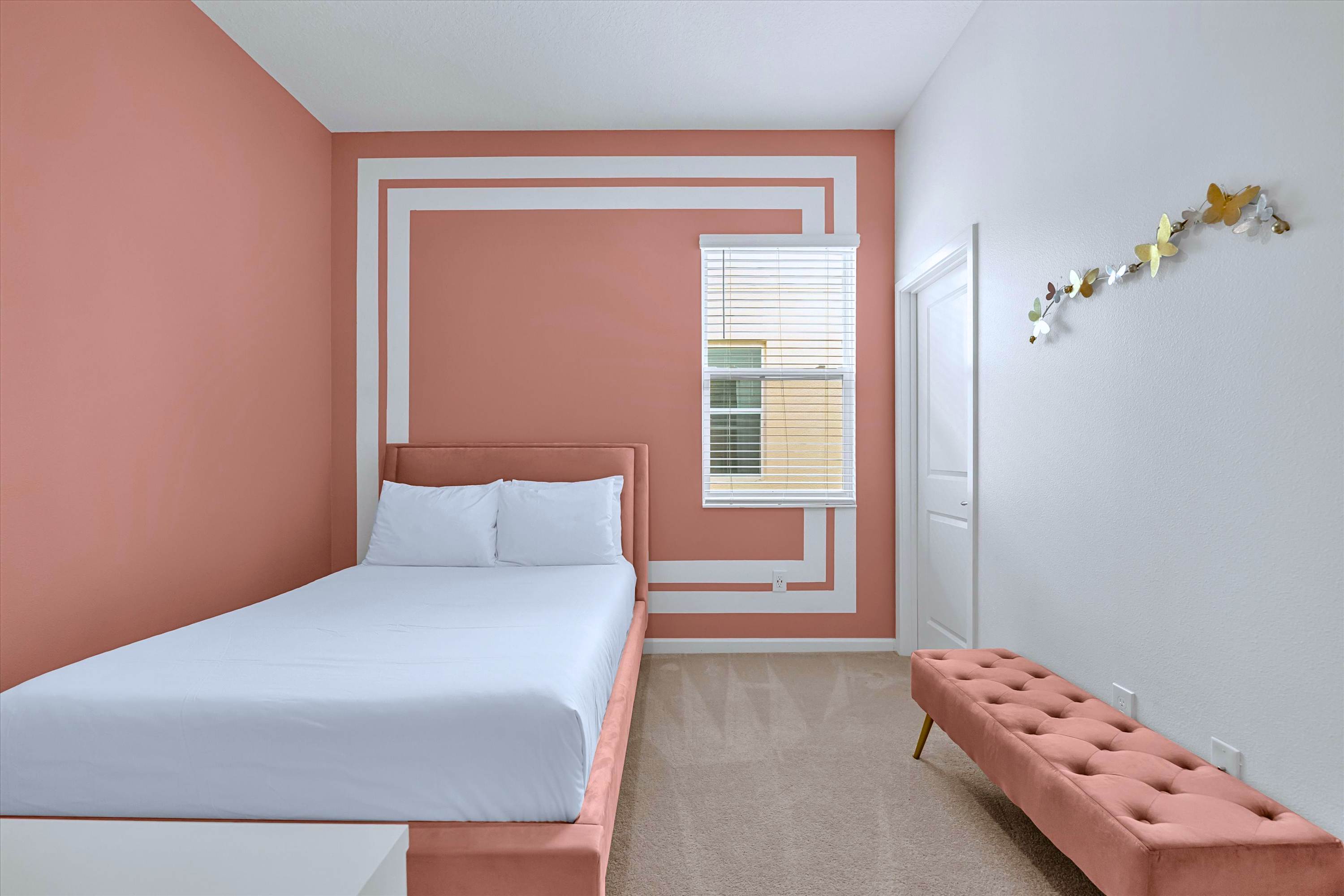 Pink-themed Queen bedroom featuring plush bedding and a comfortable end-of-bed bench