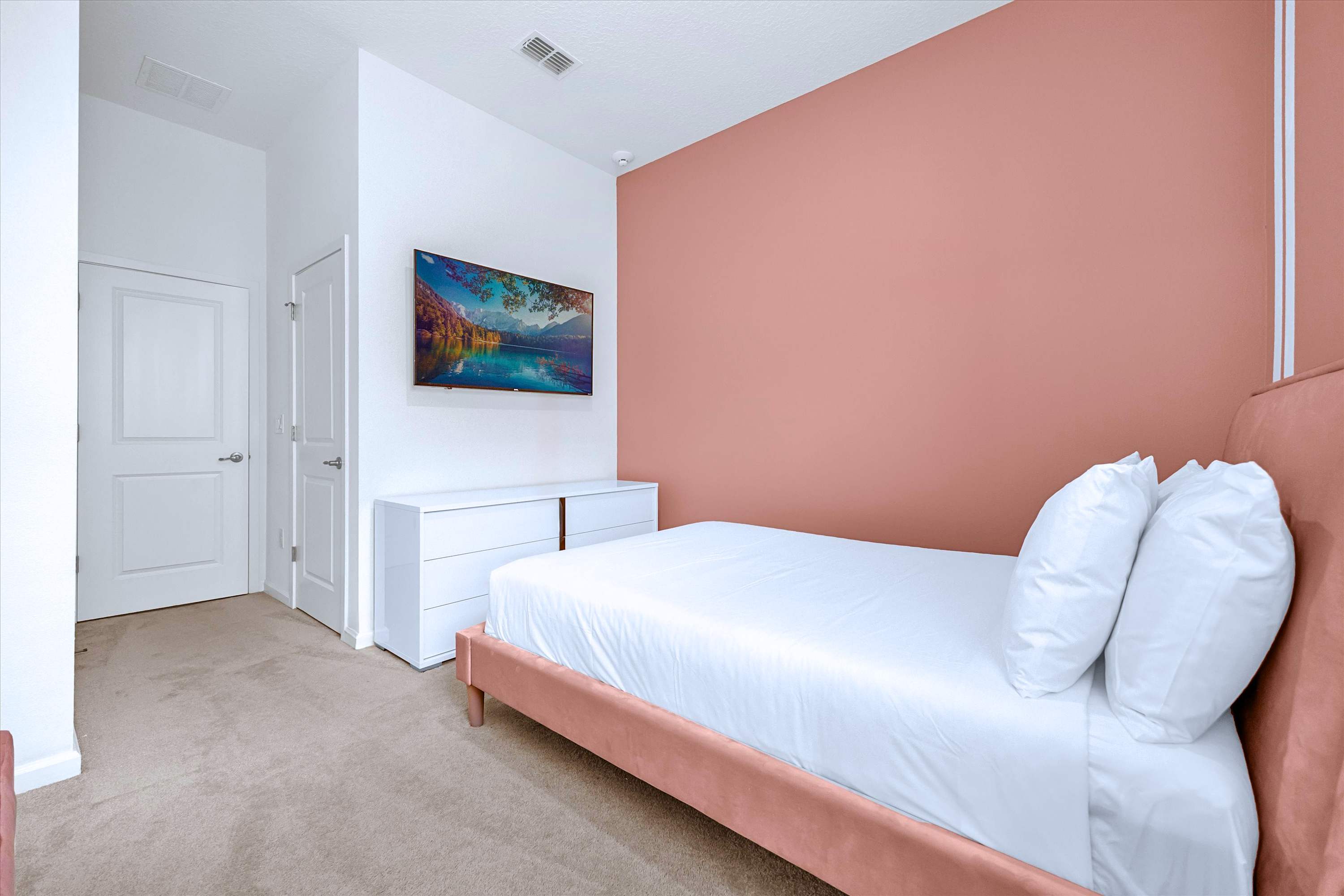 Stream in comfort: Pink Queen Bed room with luxury linens, flat-screen TV & cabinet