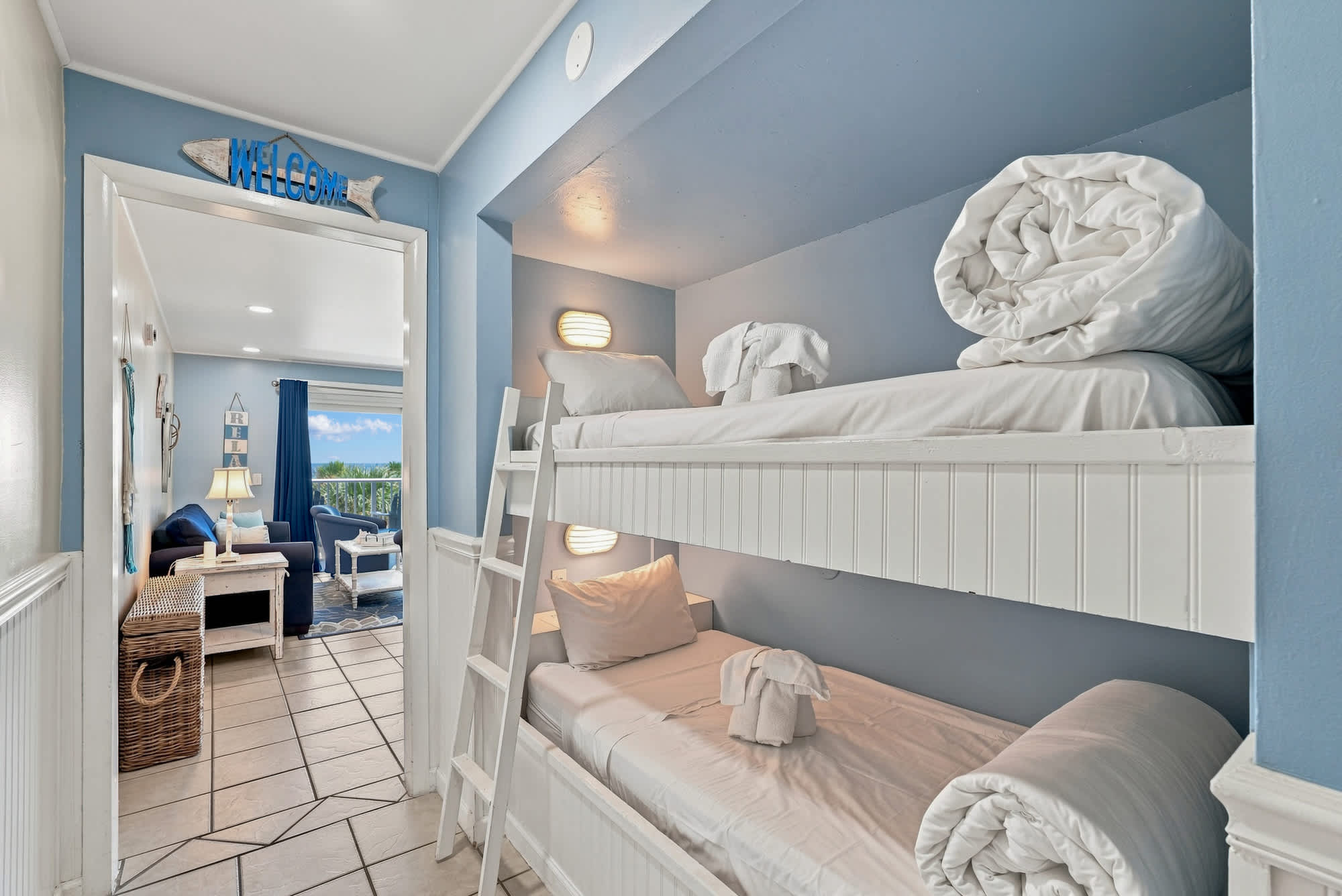 The Summit 308  – Bunk bed area with light blue walls and view of living space and outdoor balcony.
