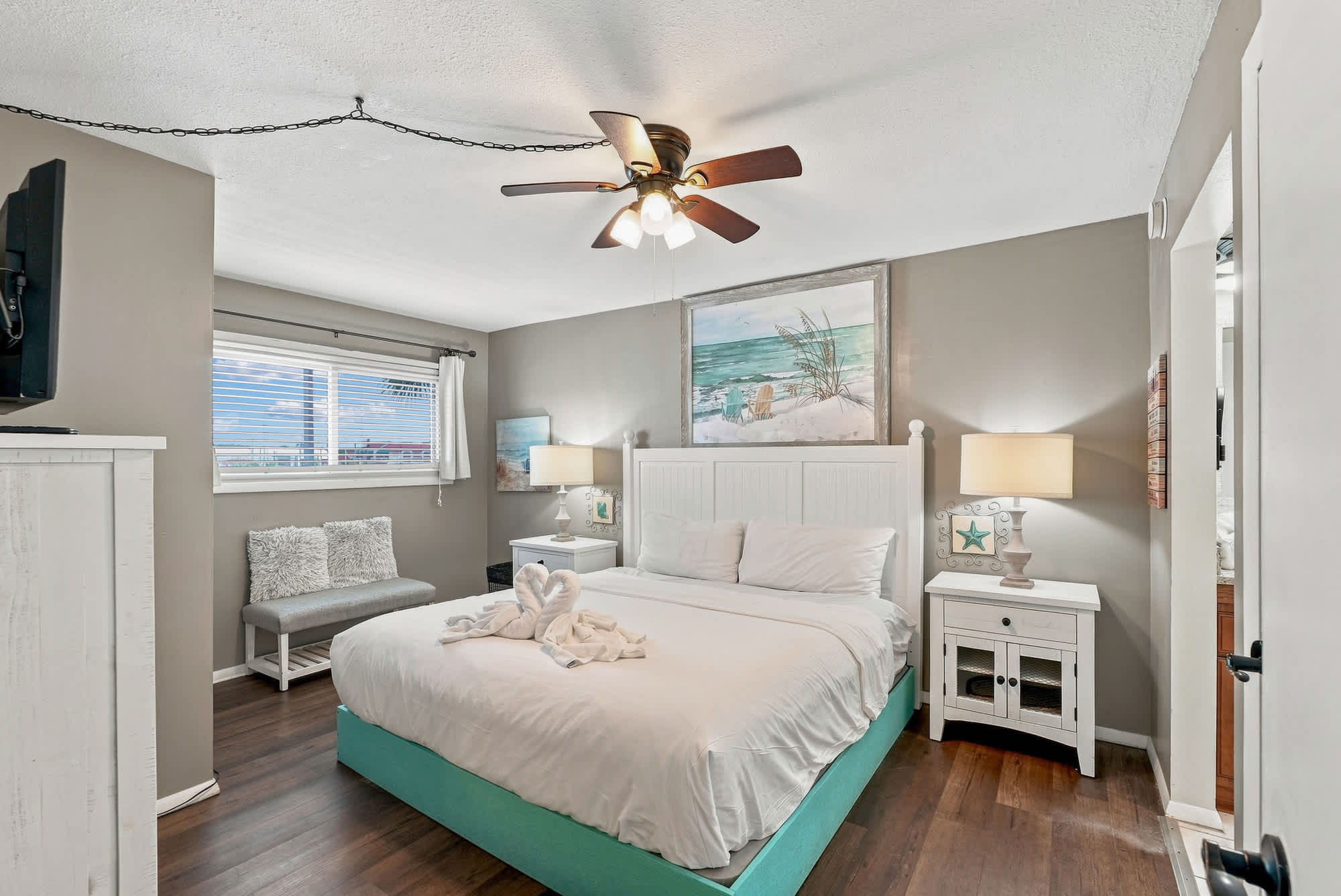 The Summit 225 – Cozy bedroom with a queen bed, nightstands, TV, and a seating area near a window.