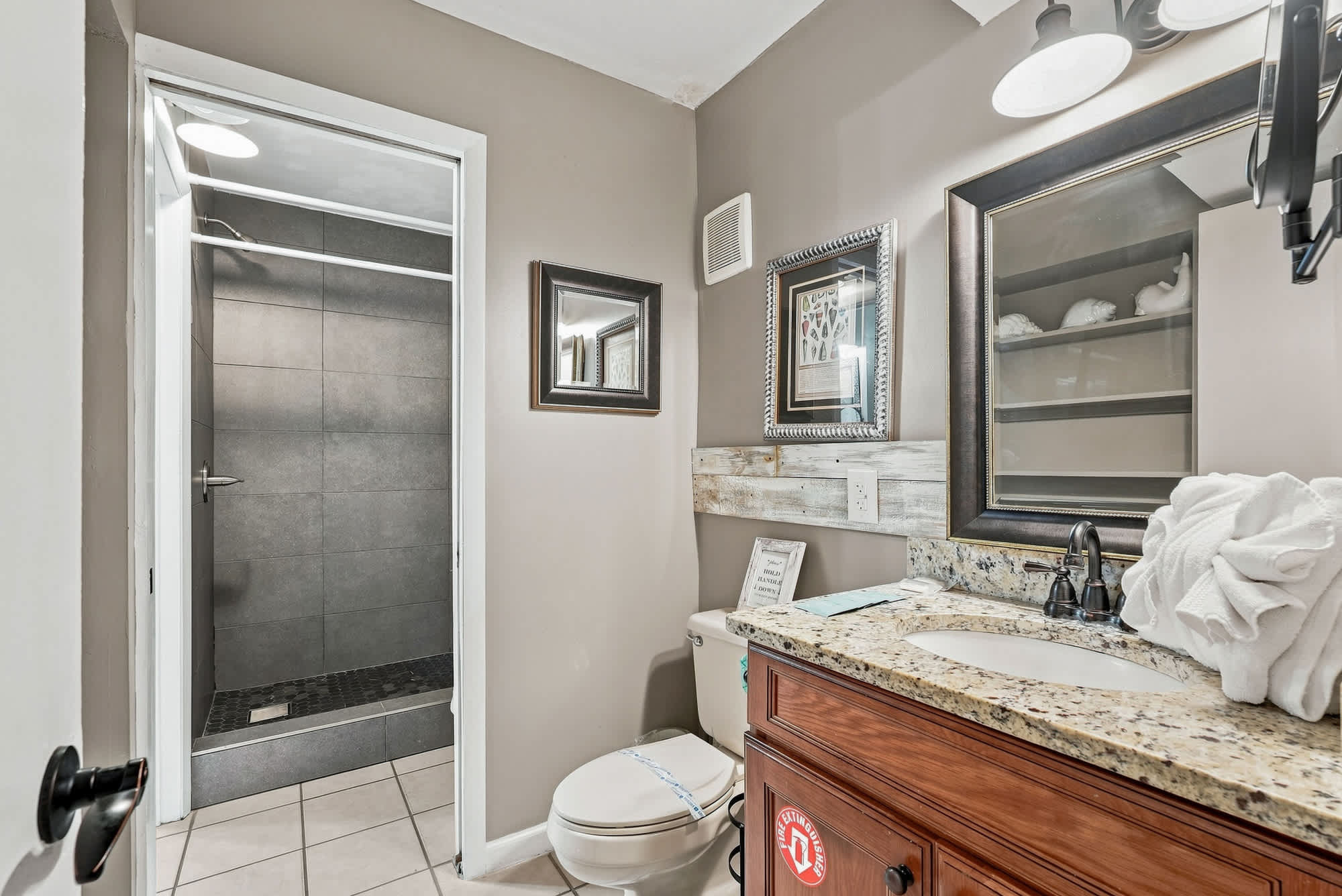 The Summit 225 – Bathroom with shower, granite countertop, and wooden storage shelves.