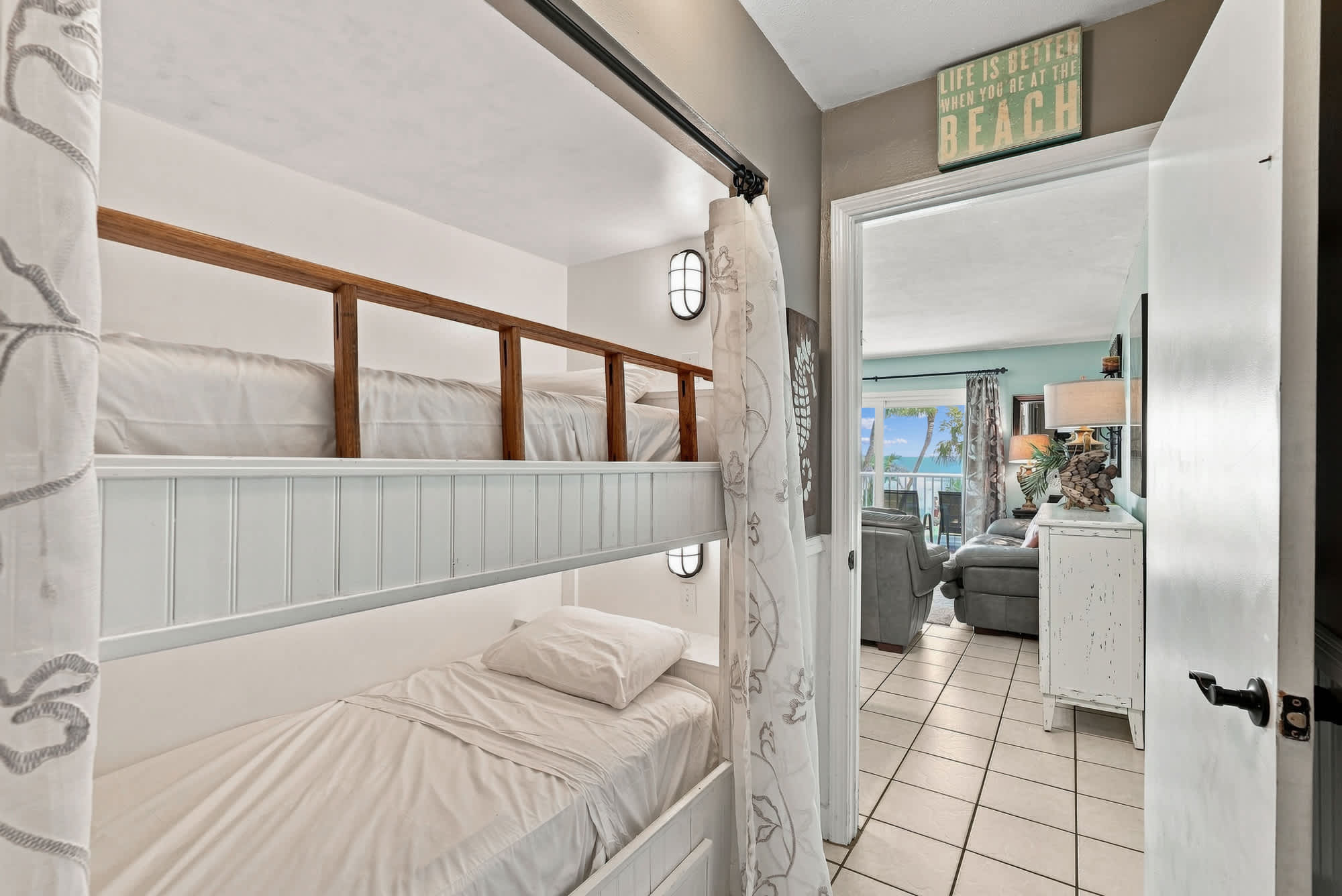 The Summit 225 – Bunk beds in a room, leading to a living area with ocean view.