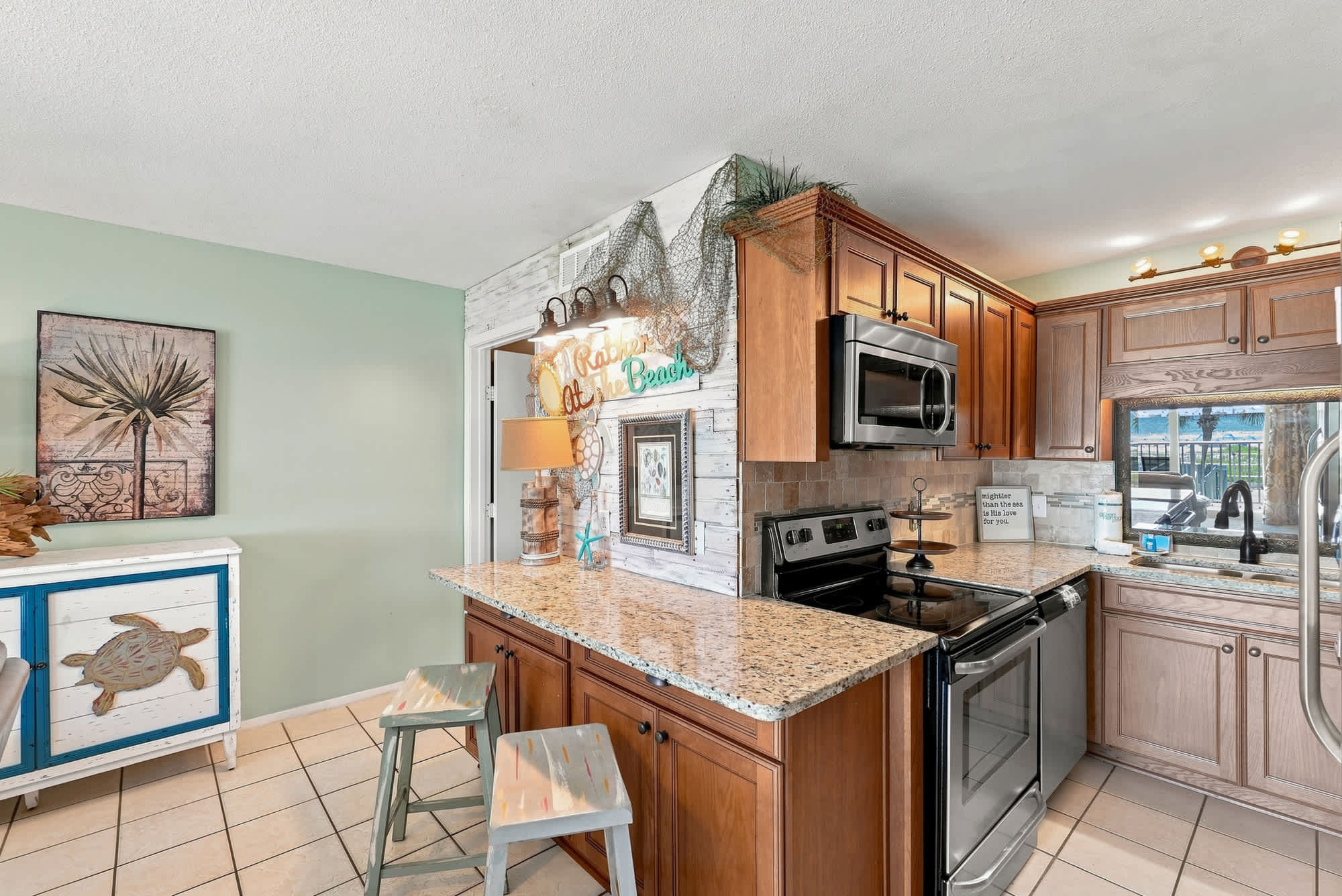 The Summit 225 – Modern kitchen with wooden cabinets, granite countertops, and island seating by the window.
