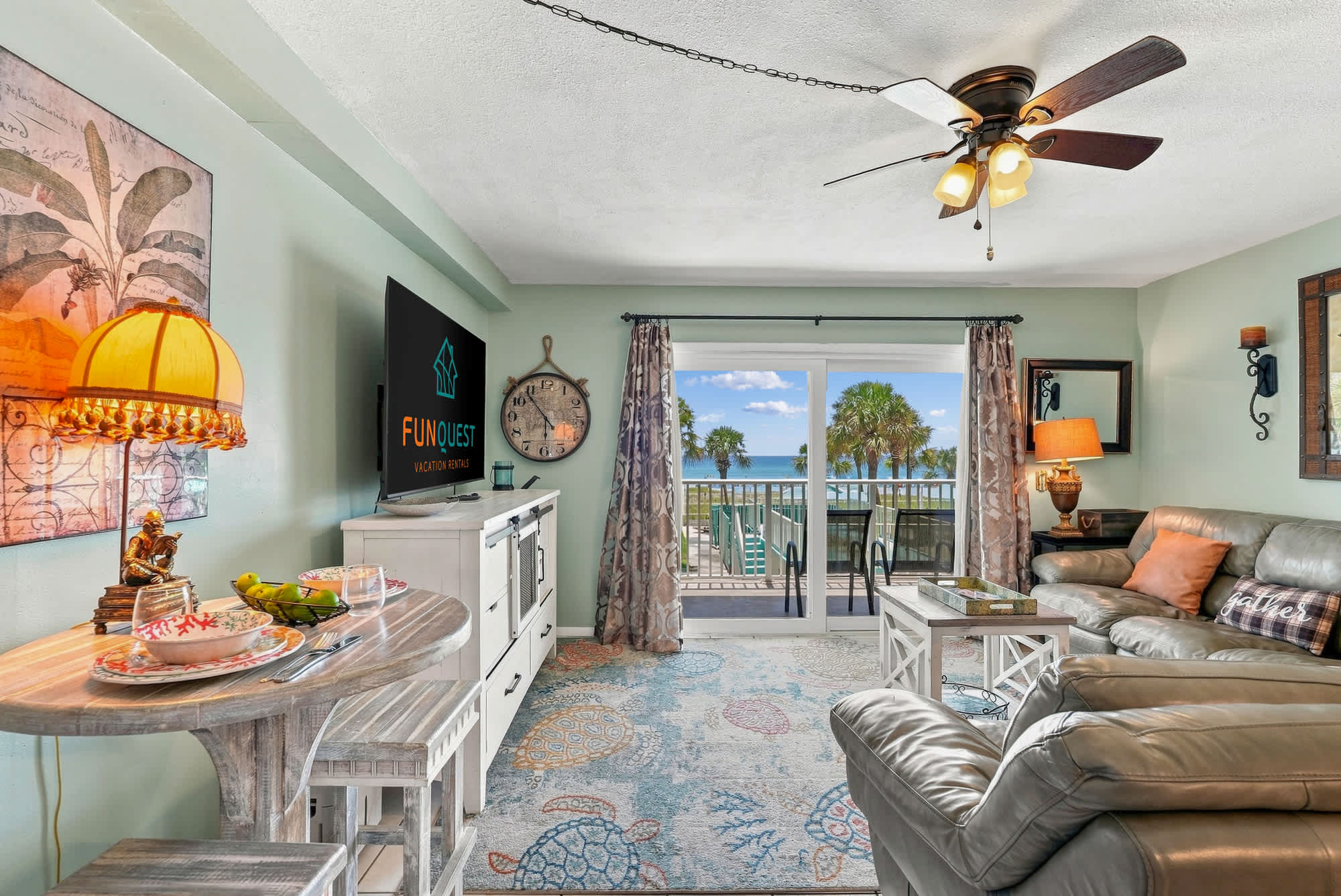 The Summit 225 – Living room with ocean view, sofa, small dining table, and decorative features.