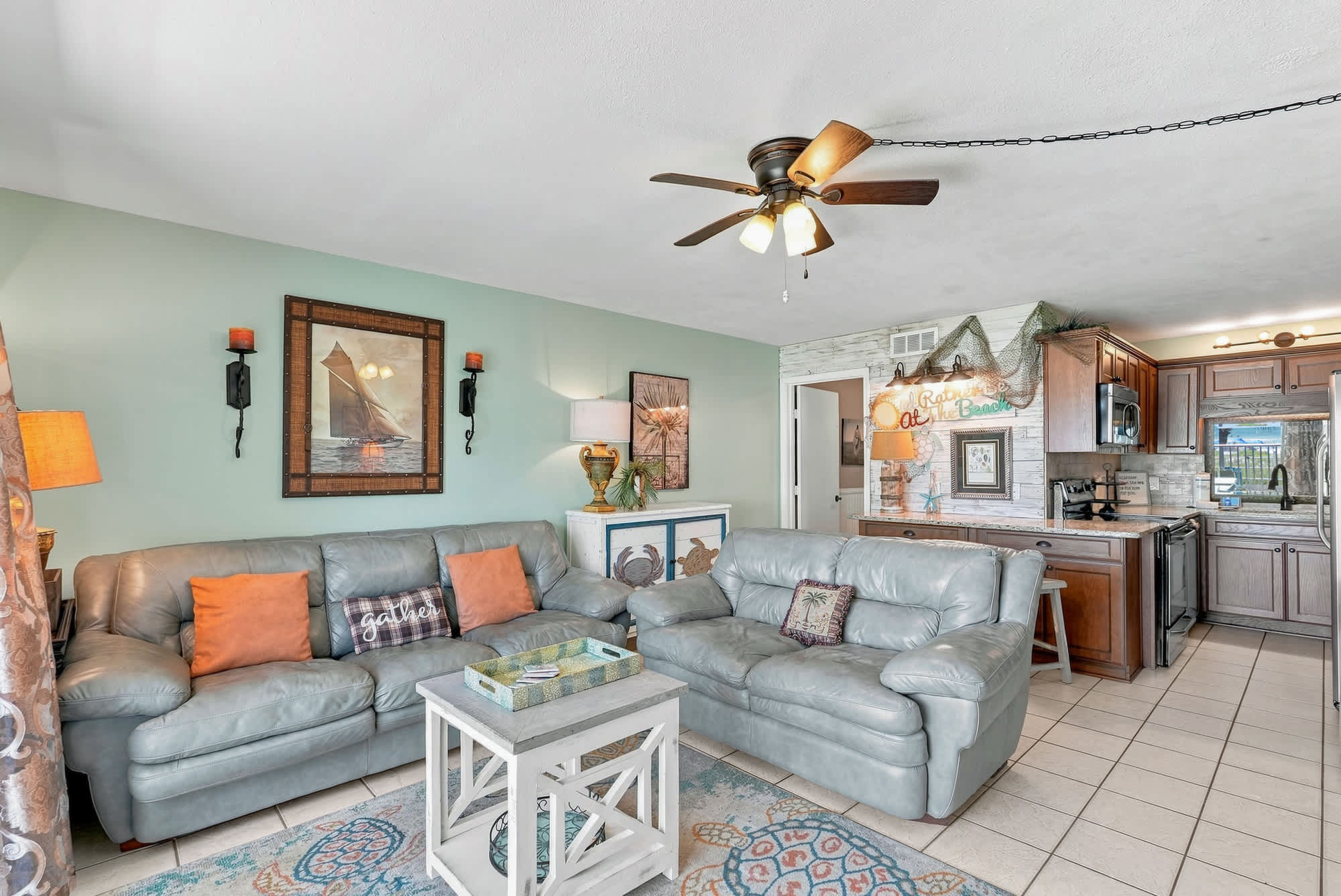The Summit 225 – Cozy living room with leather sofas, coffee table, and kitchen area visible in the background.