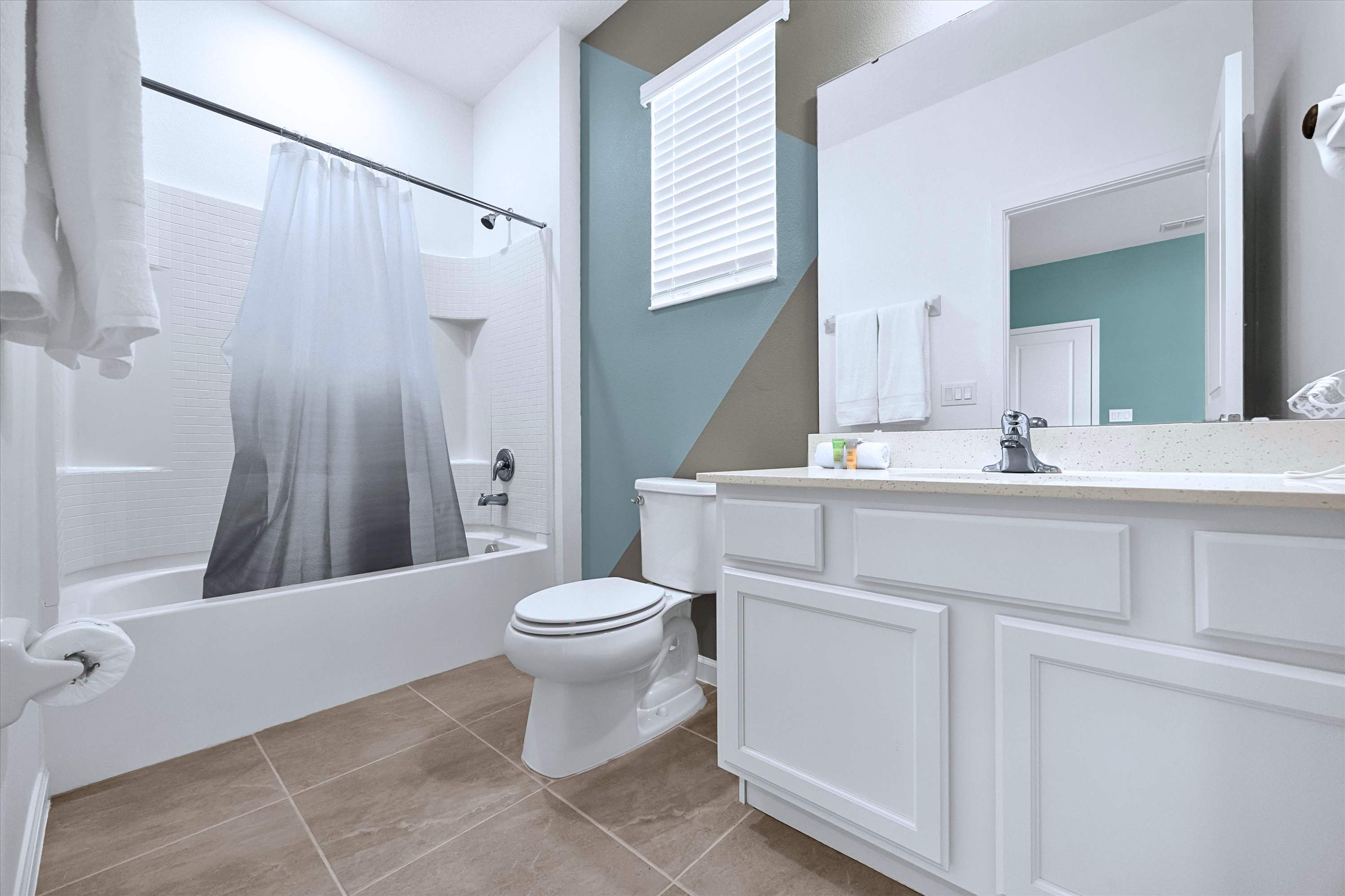 En-suite full bathroom featuring a glass walk-in shower, sink vanity, mirror & toilet