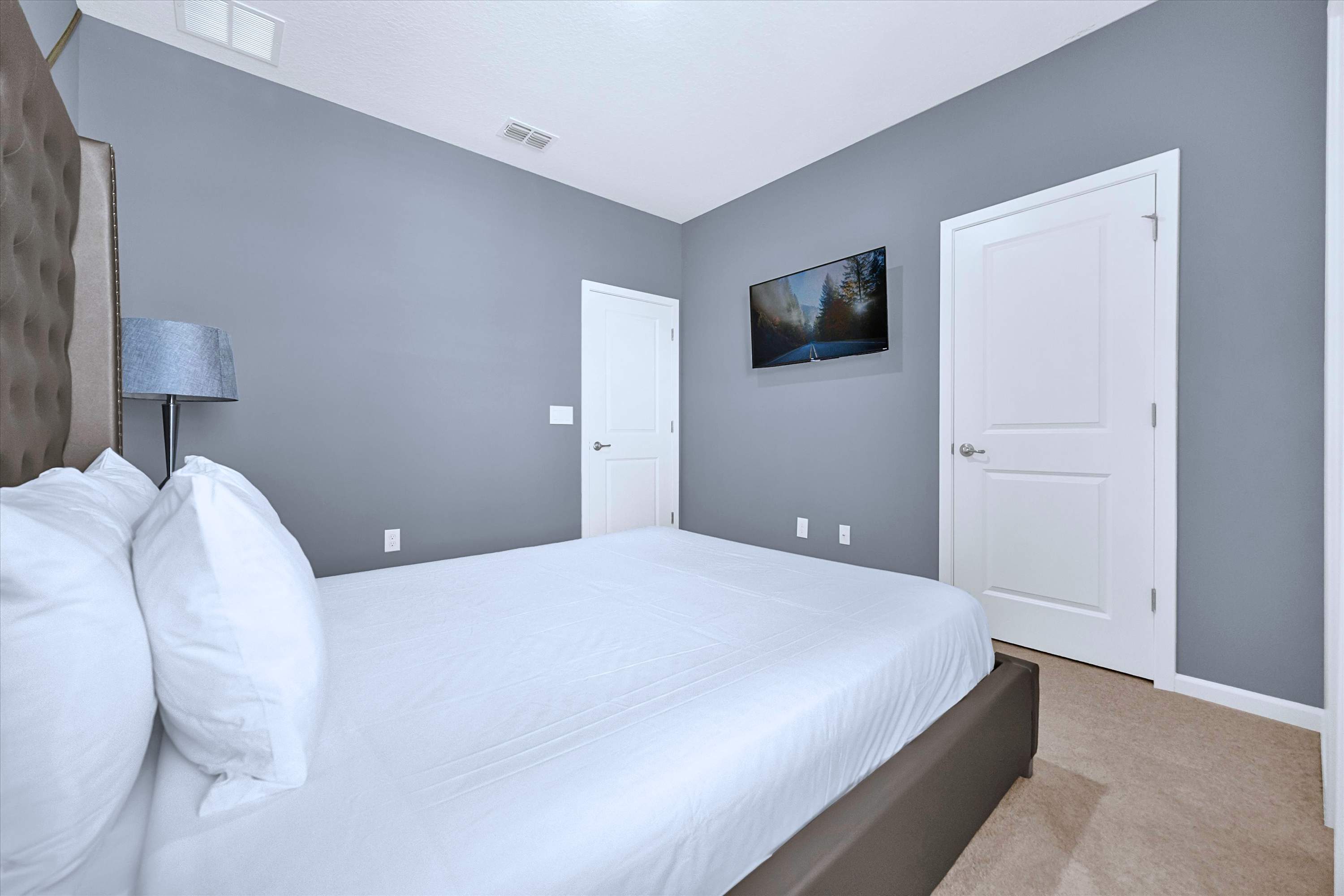 Stream from bed: Queen Bed featuring custom headboard, luxury linens & flat-screen TV