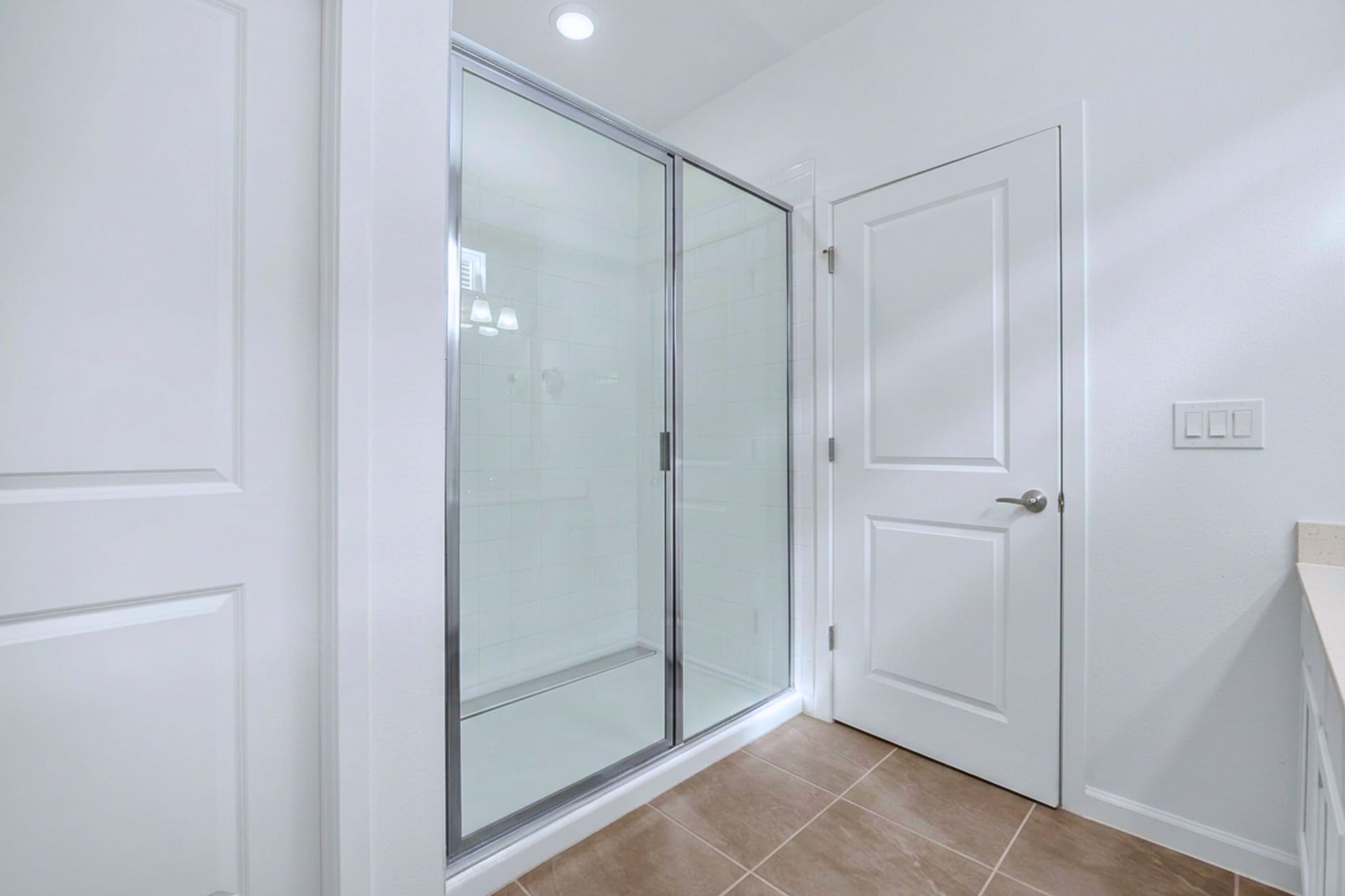 En-suite bathroom setup featuring a glass walk-in shower and modern tile