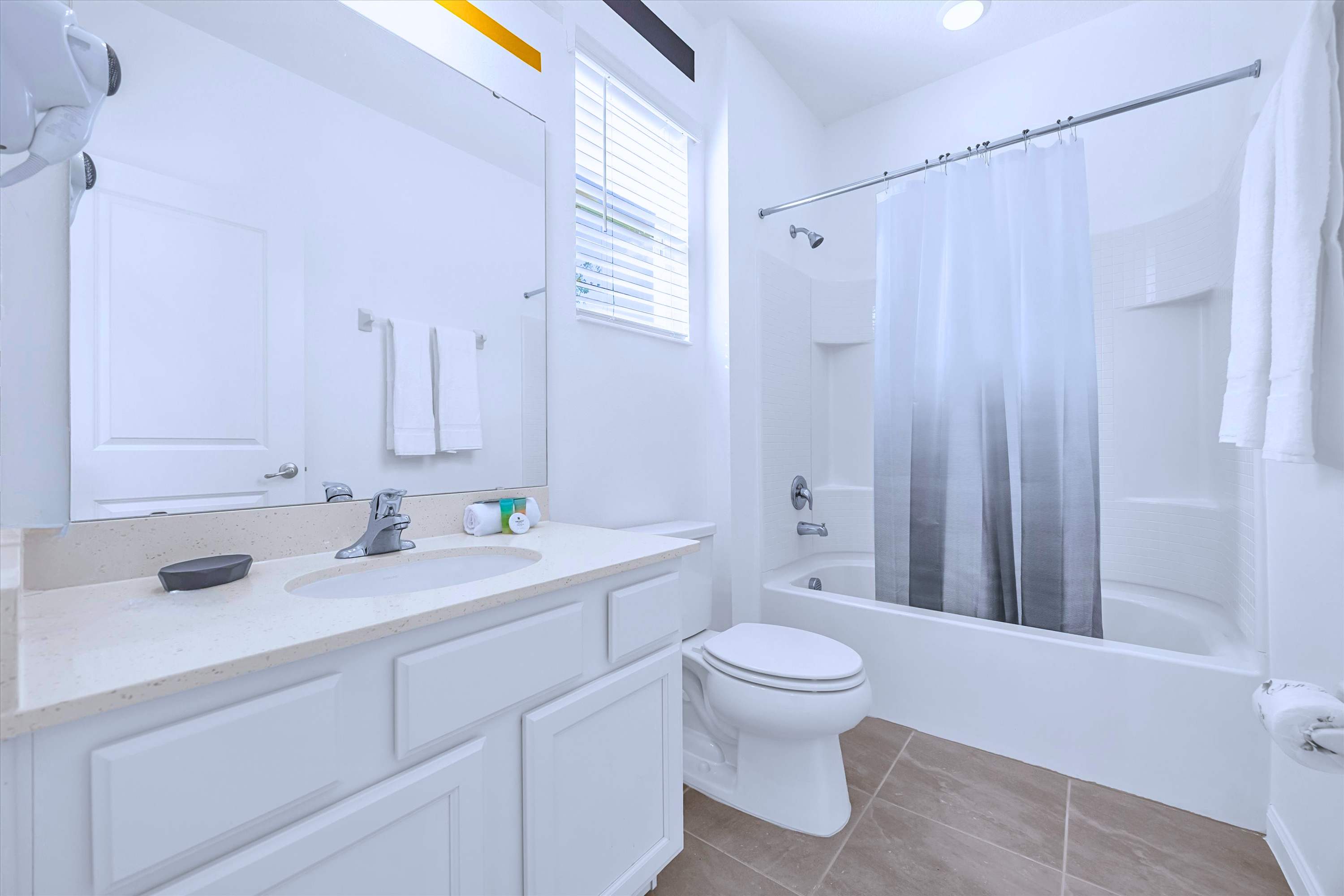 Private en-suite bath equipped with bathtub shower combo, mirror, sink & toilet