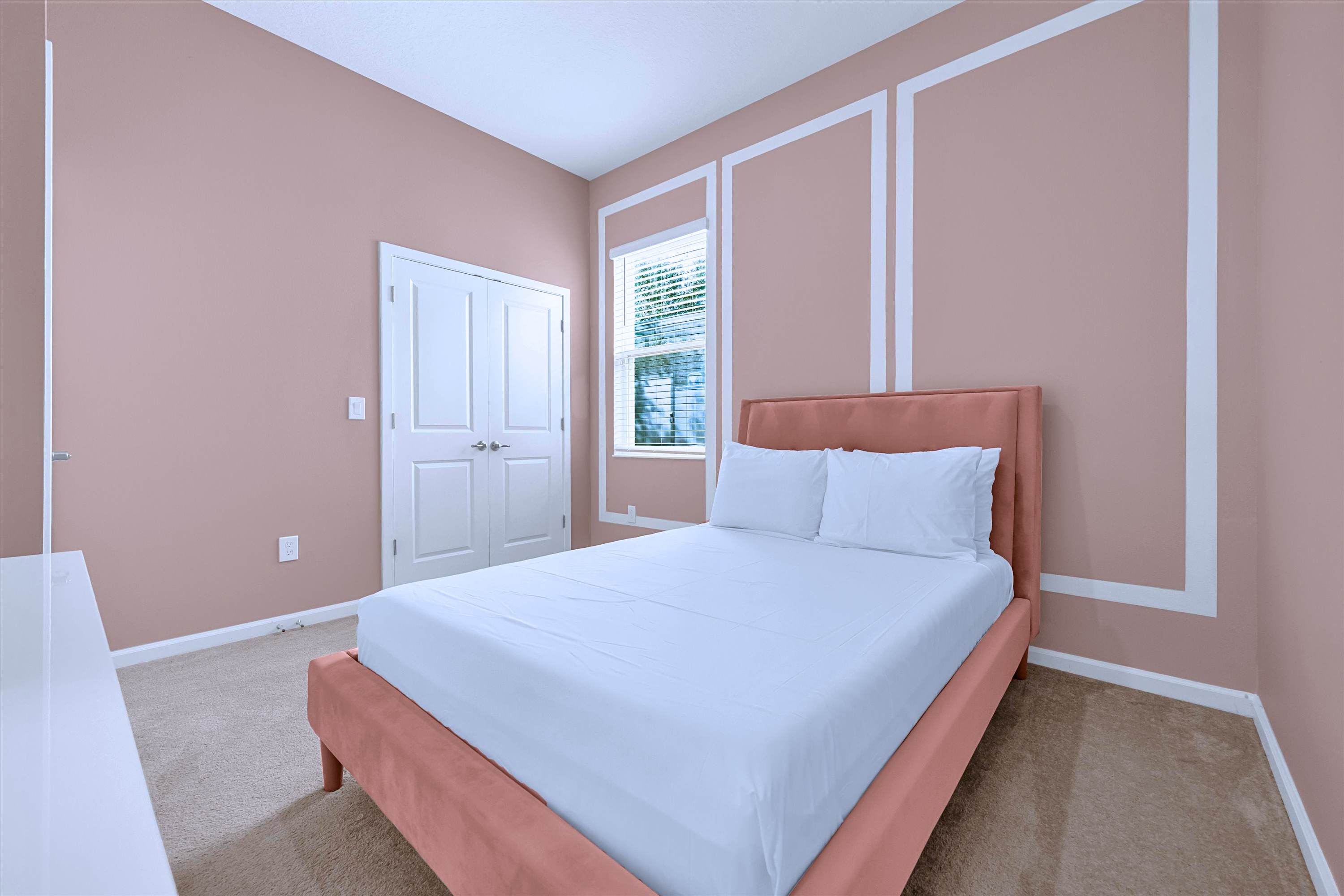 Cozy pink themed bedroom setup with soft bedding and private en-suite bath access