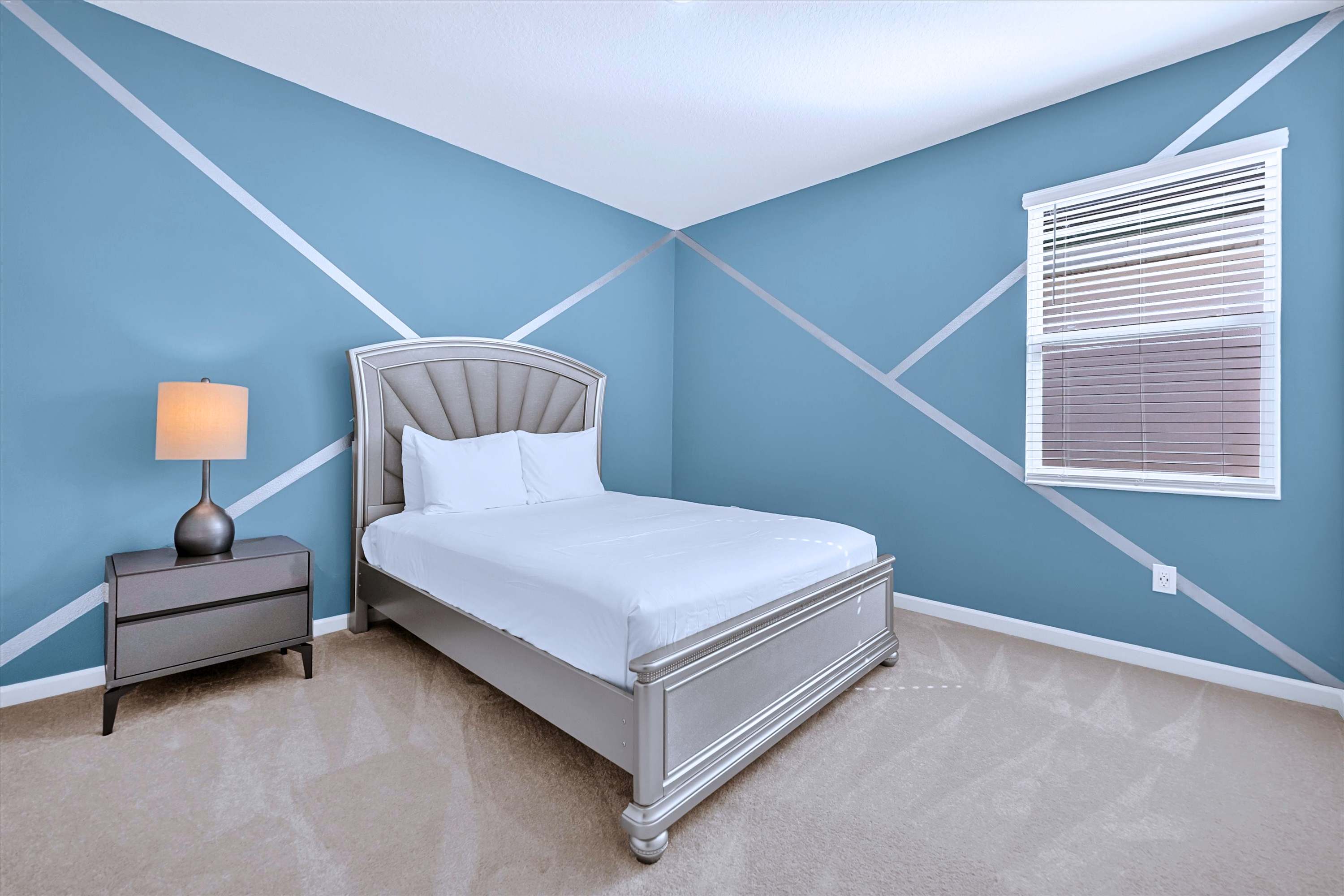 Cozy blue themed bedroom equipped with Queen Size Bed, plush linens & side lamp