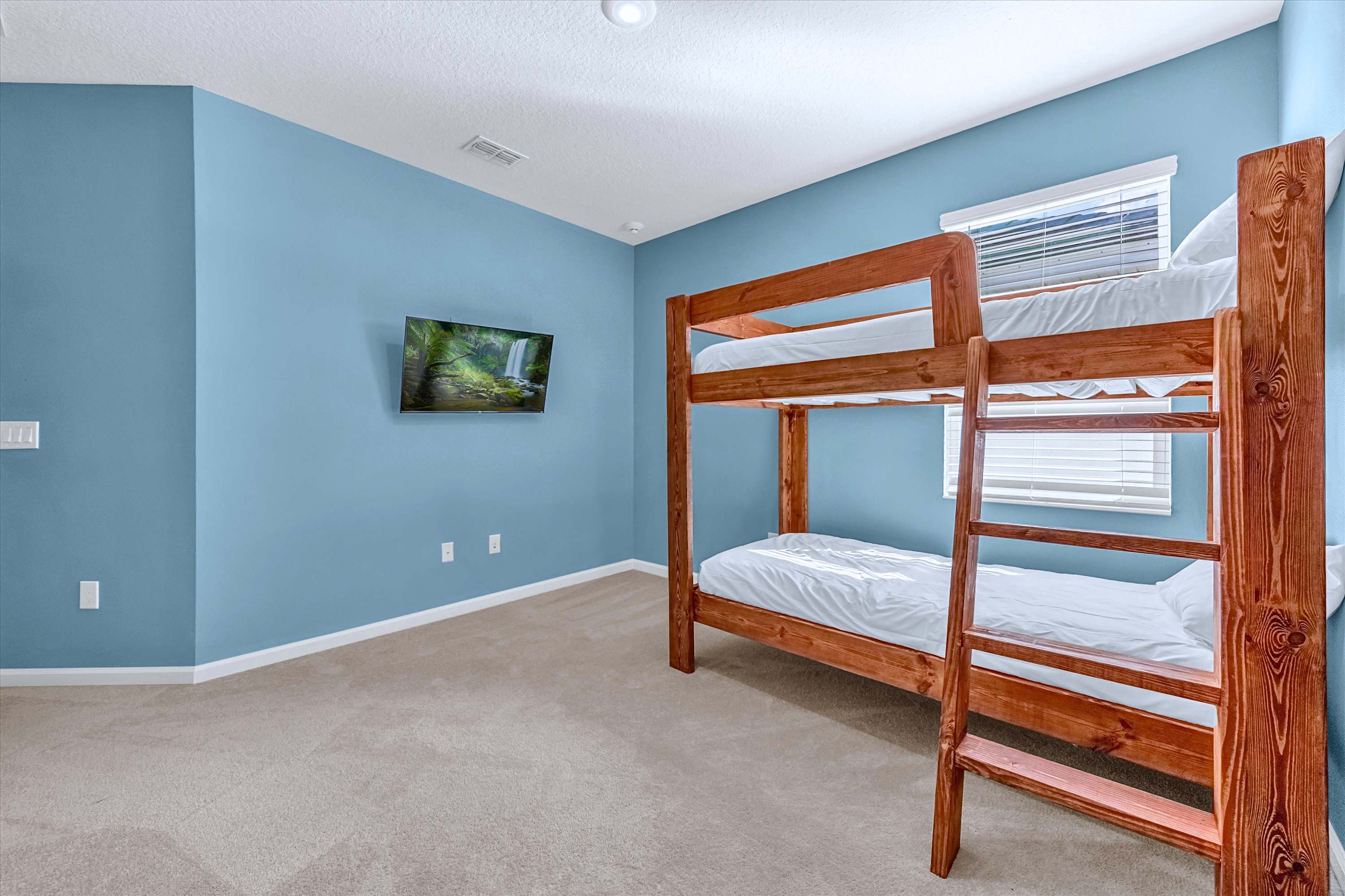Cartoon-themed bunk room featuring a flat-screen TV for bedtime entertainment