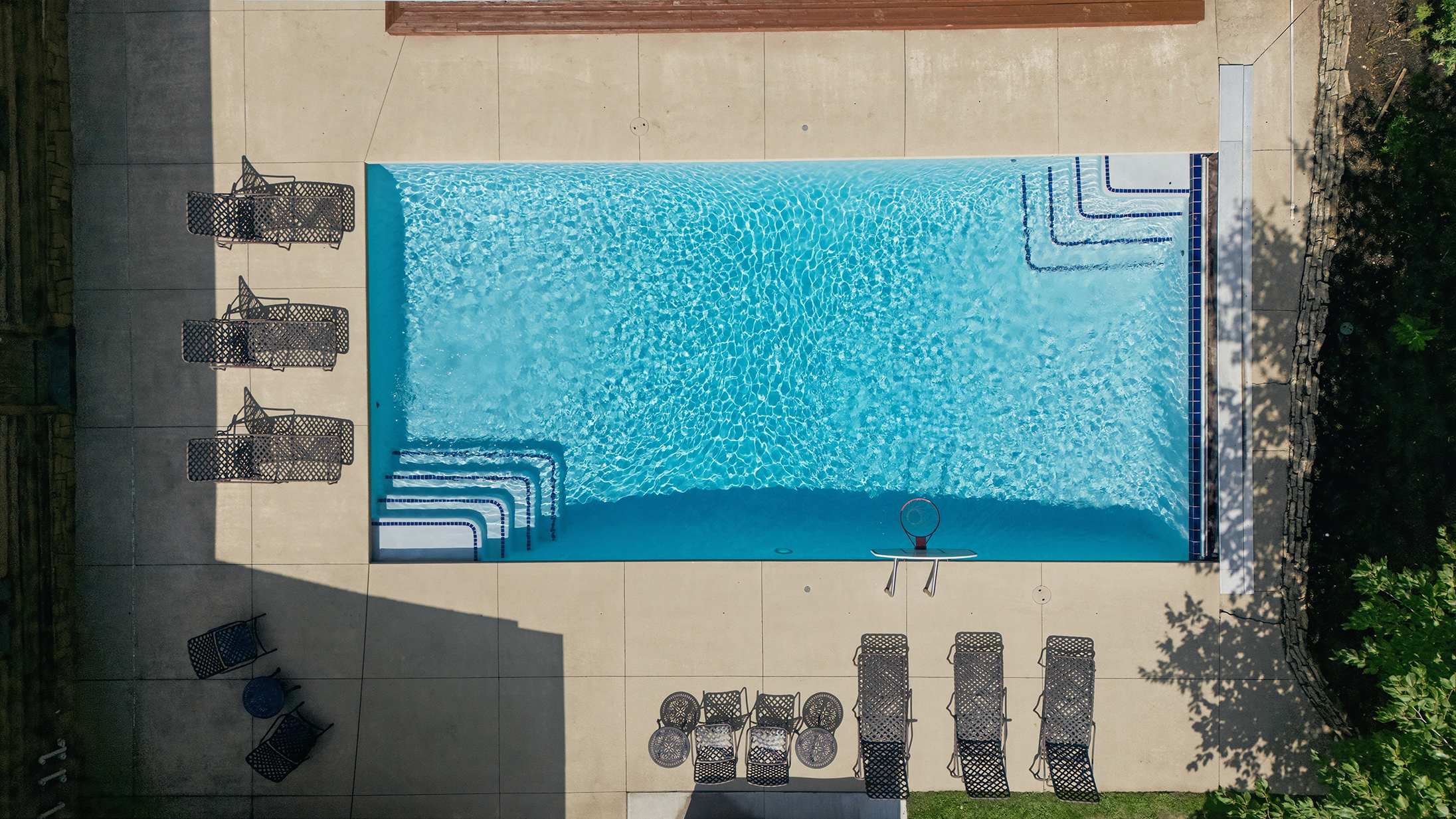 Outdoor pool with a spacious deck and seating for the whole group.