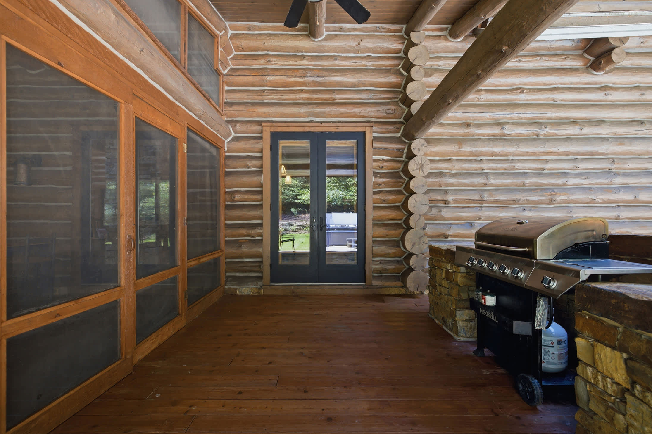 Screened porch with a gas grill for convenient outdoor cooking.