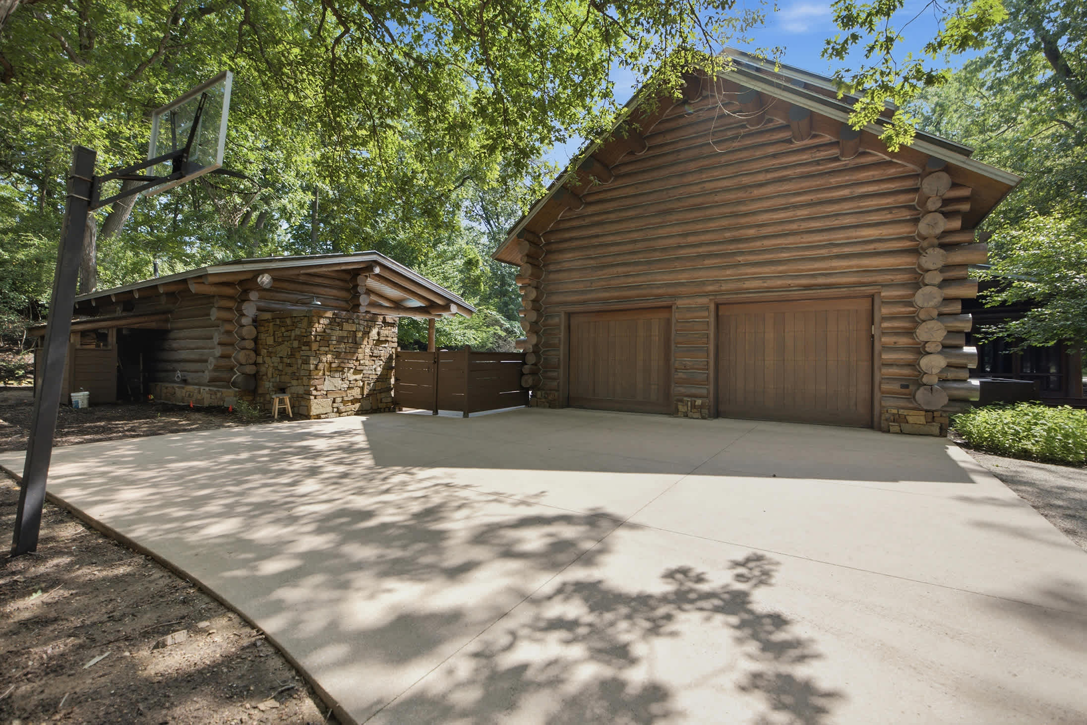 This stunning log home features two spacious garages and a welcoming driveway.