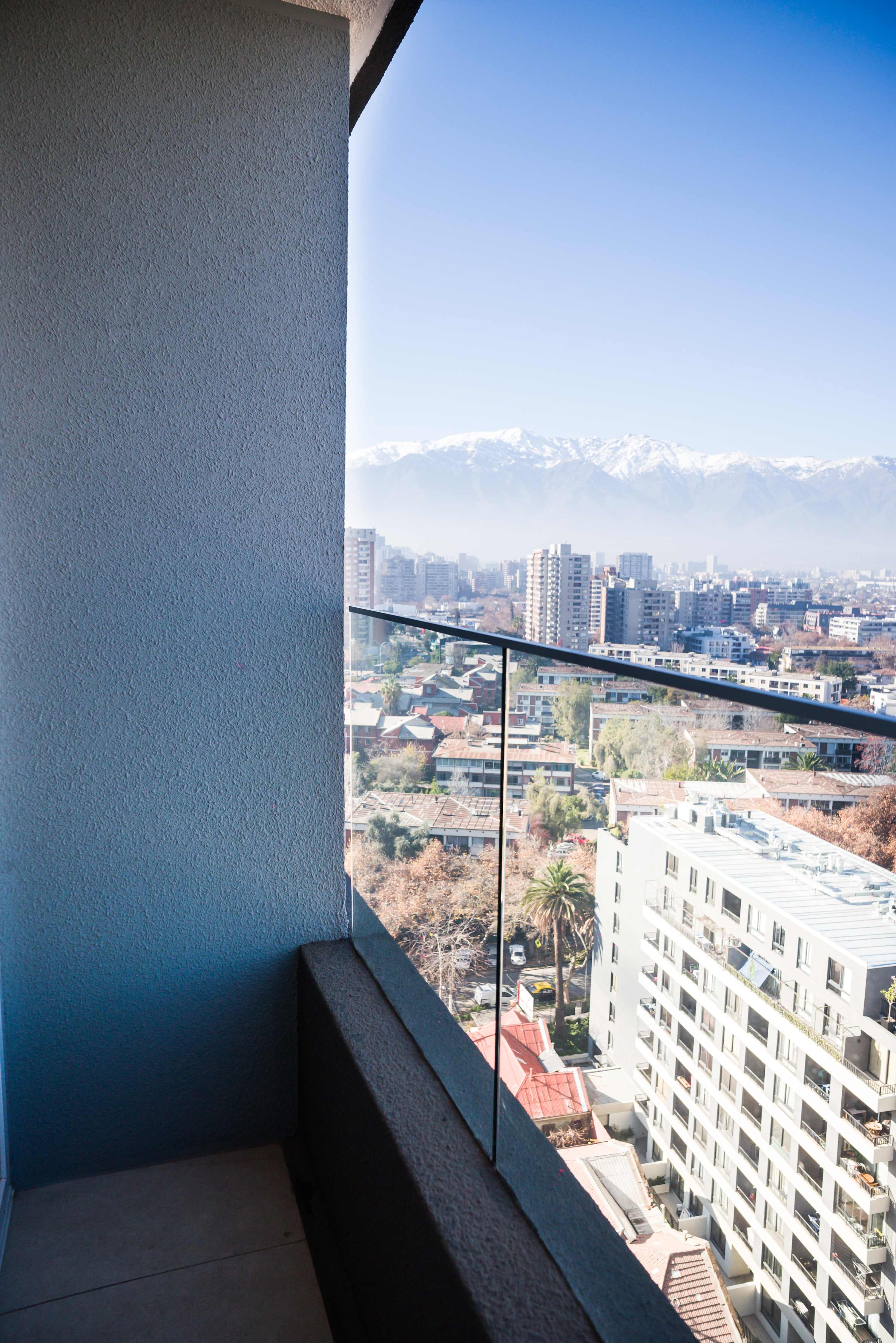 Private balcony with sweeping city views and snow-capped mountains on the horizon