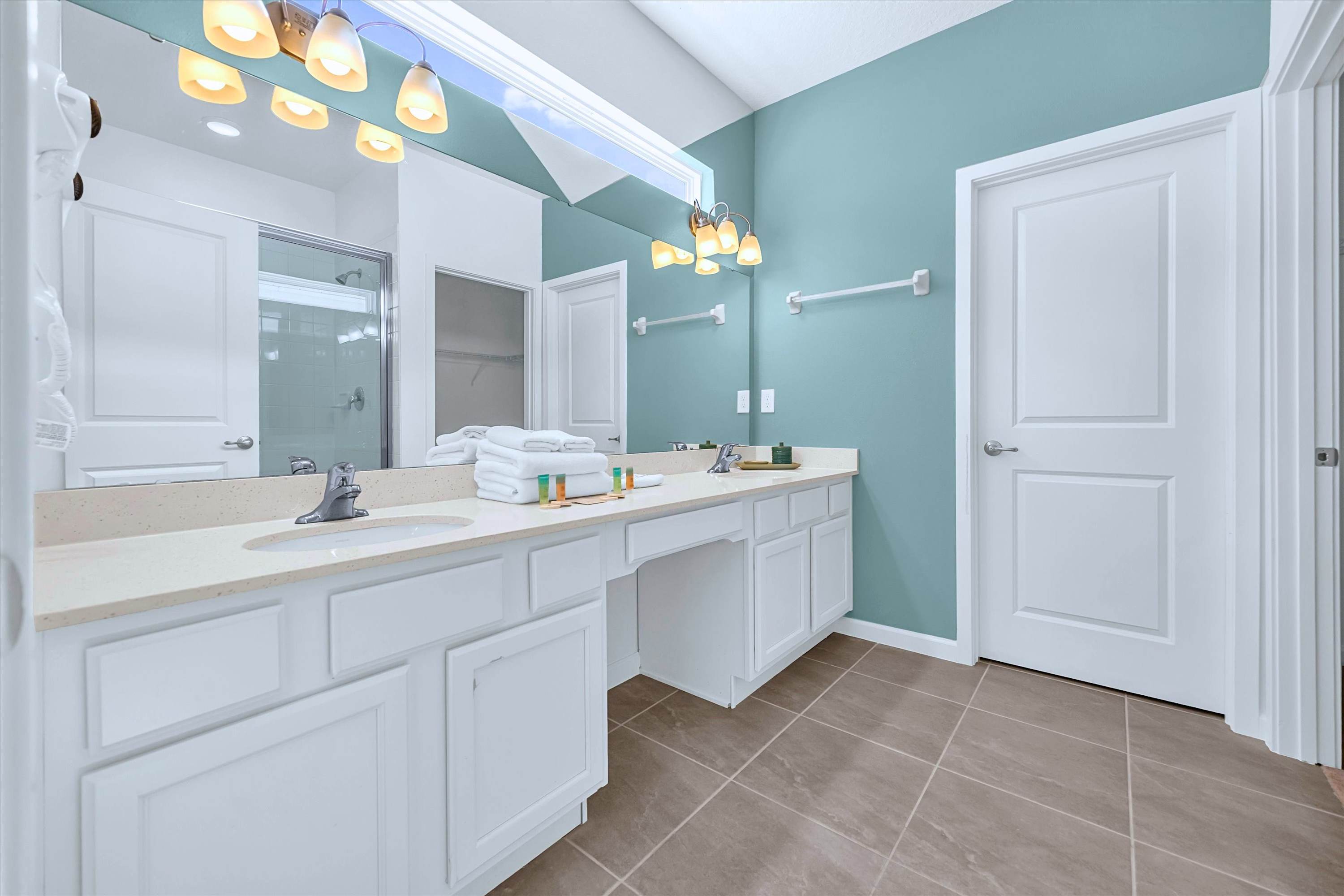 Settle into a modern dual-sink bathroom with a large mirror to get ready in comfort