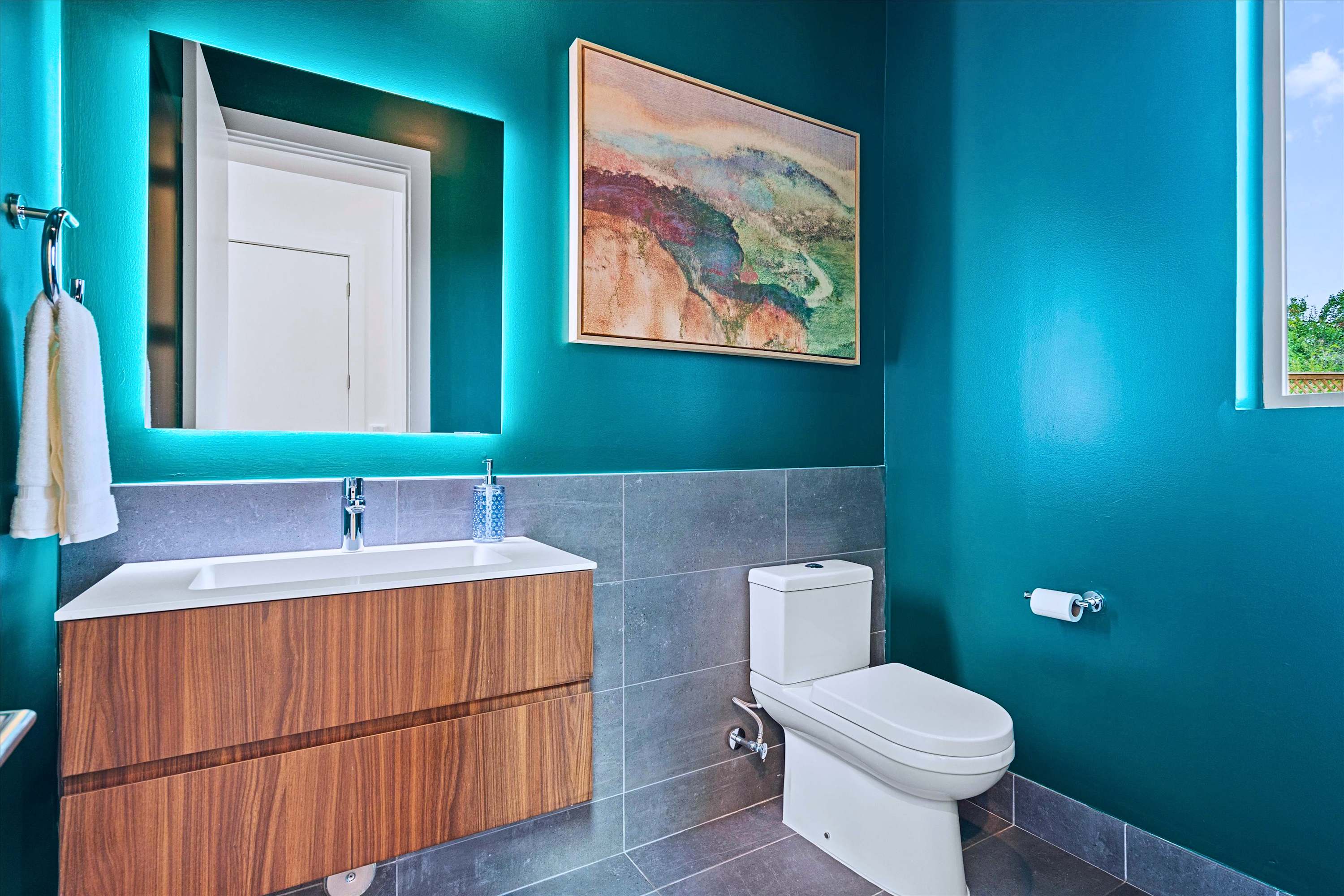 Clean Half Bath Featuring an Illuminated Vanity Mirror