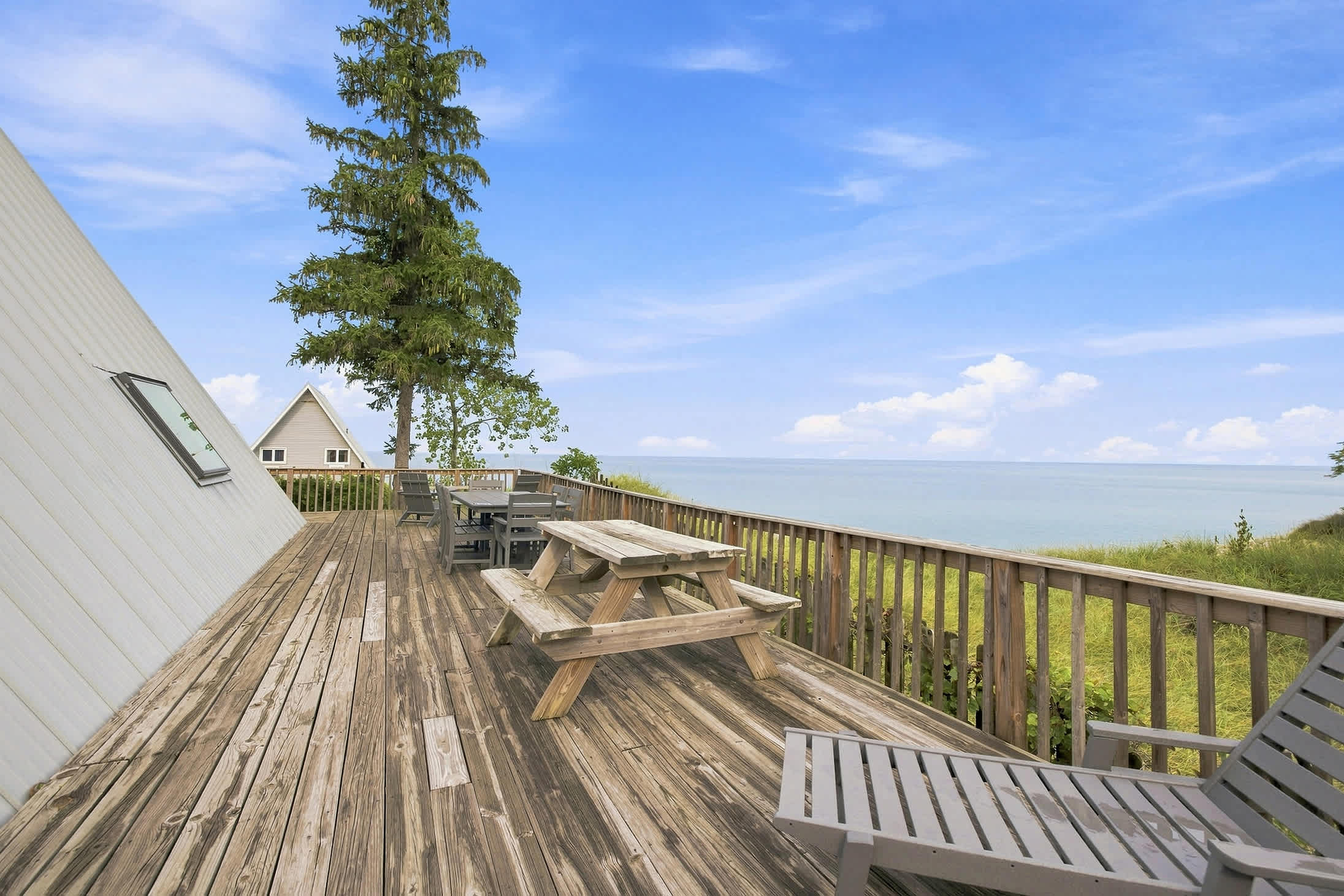 Lakefront deck with picnic table seating for outdoor meals overlooking the water.