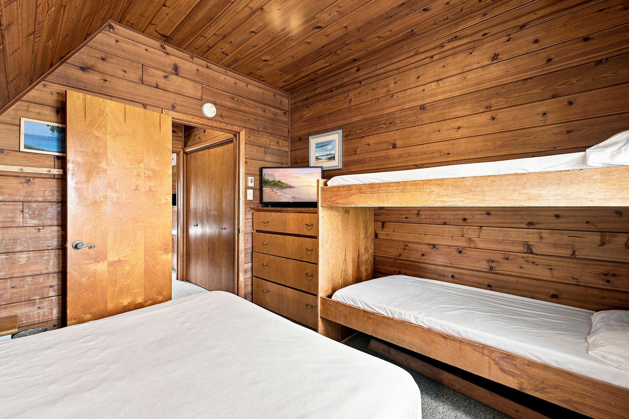 Bedroom 1 includes a TV and dresser for added comfort and storage.