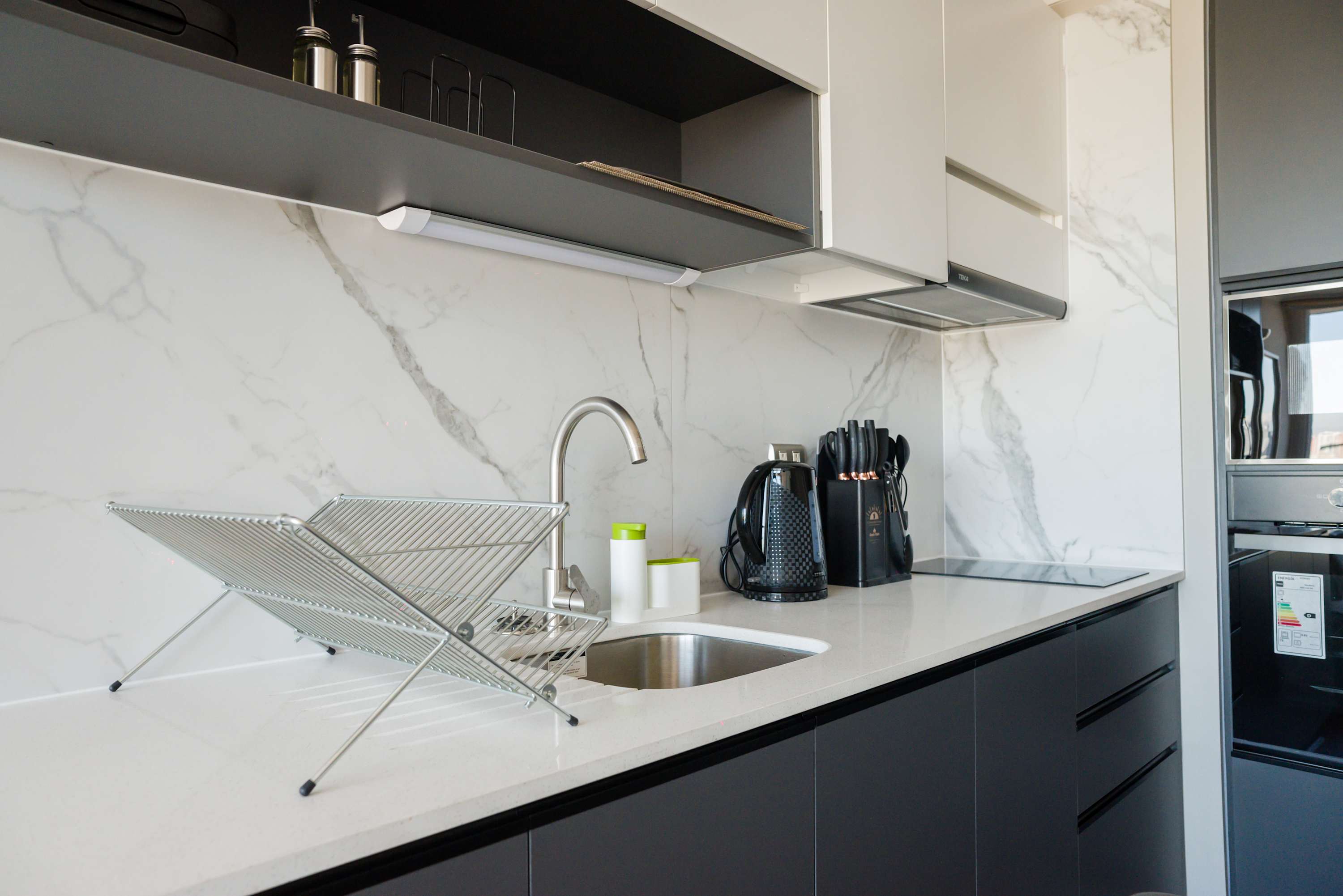 Private kitchen with marble-look finishes, an induction cooktop, built-in oven, and compact appliances for convenient meal preparation.
