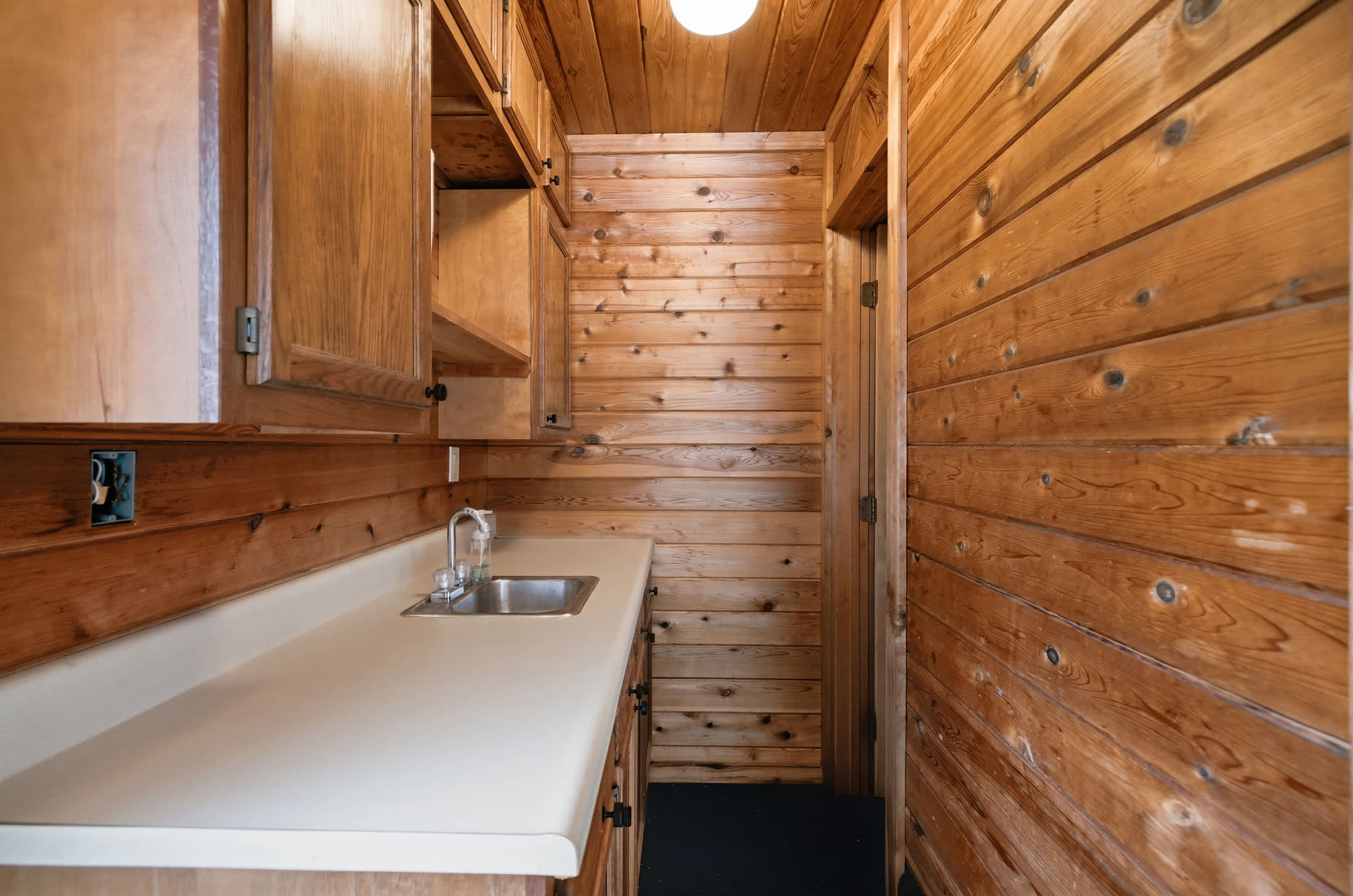 Pool house kitchenette includes a sink and counter space for added convenience.