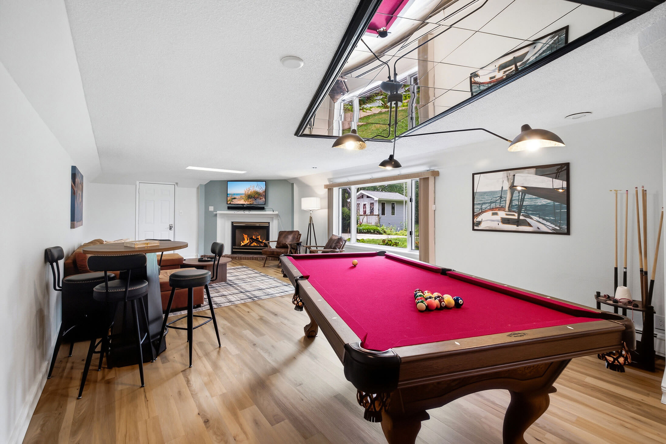 Main-level game room with a pool table, TV, and seating for group hangouts.