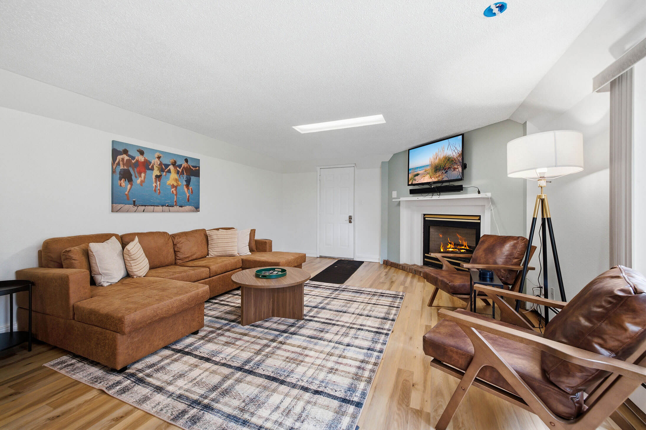 Main-level living area with sectional seating, a TV, and a gas fireplace.