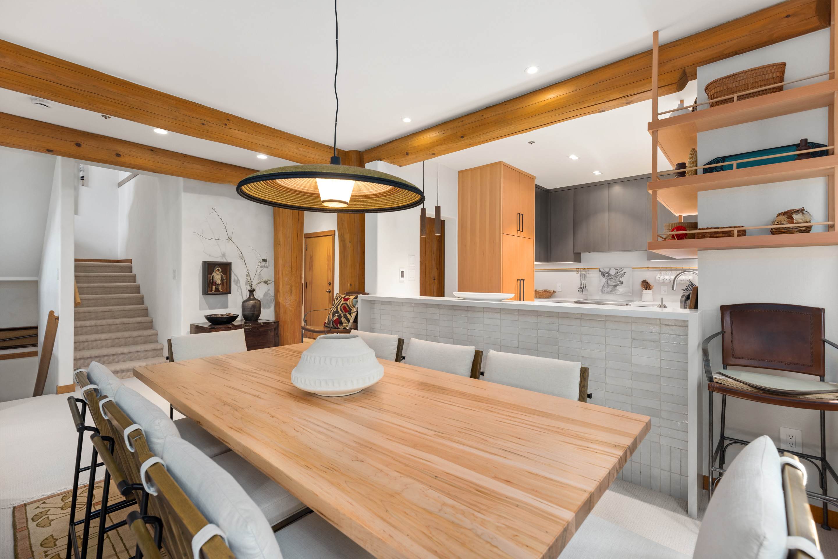 - Open concept kitchen and dining 
- Wooden cabinetry and high-end appliances for chef-style cooking 
- Long dining table ideal for shared mountain meals