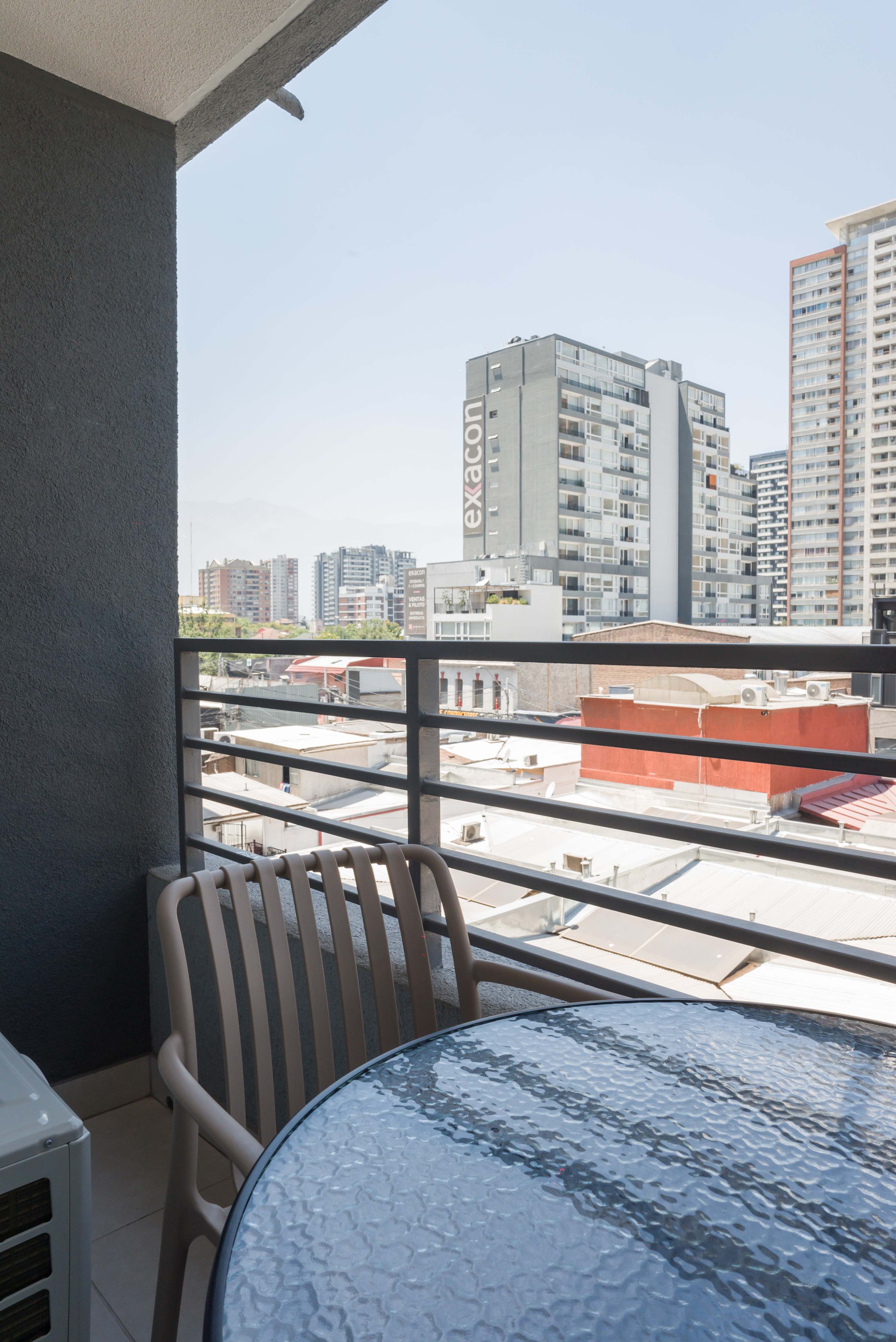 Balcony with city views, a glass-top table, and seating for relaxed outdoor meals or morning coffee.