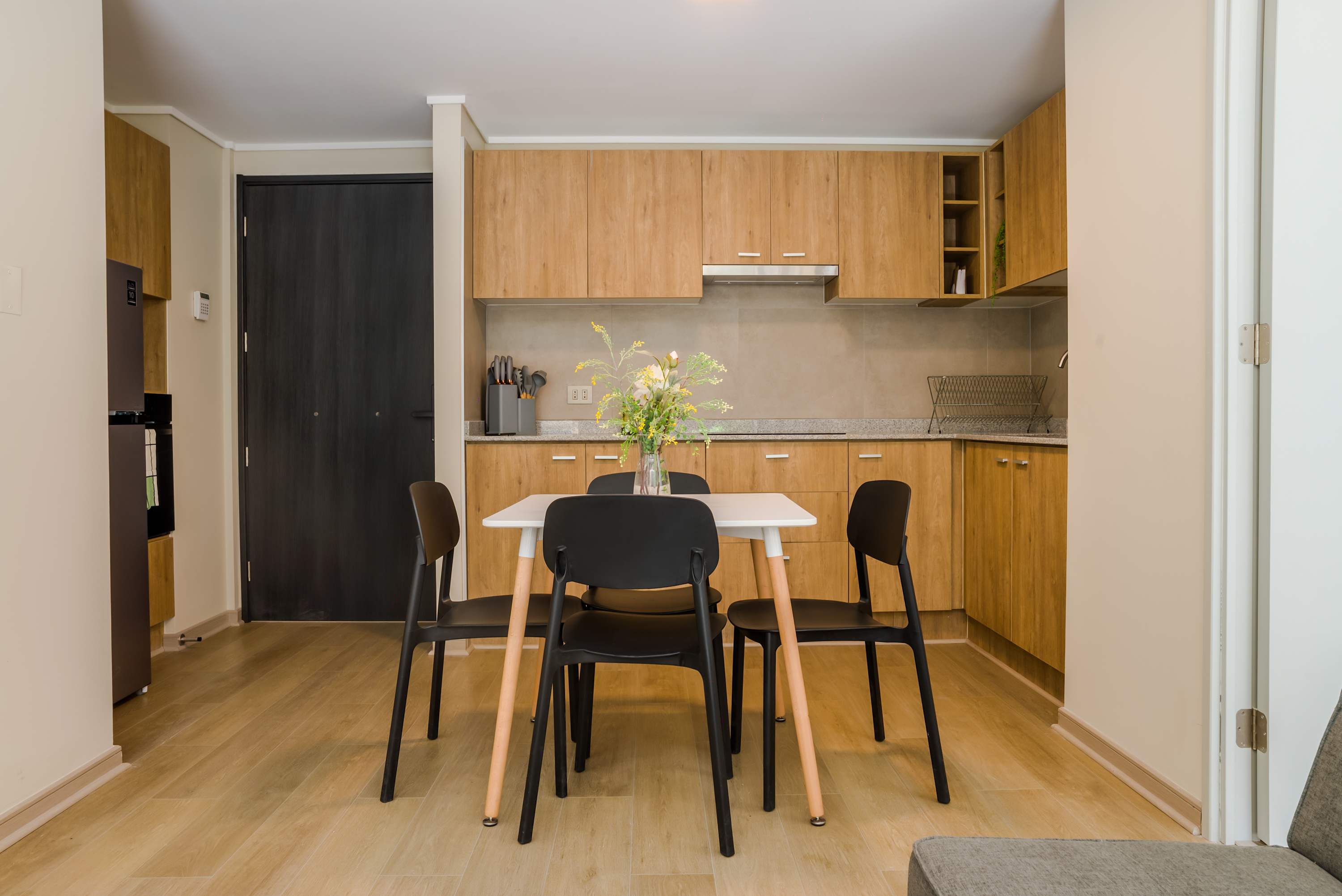 Private kitchen with warm wood cabinetry, a stone countertop, and a dining table seating five.