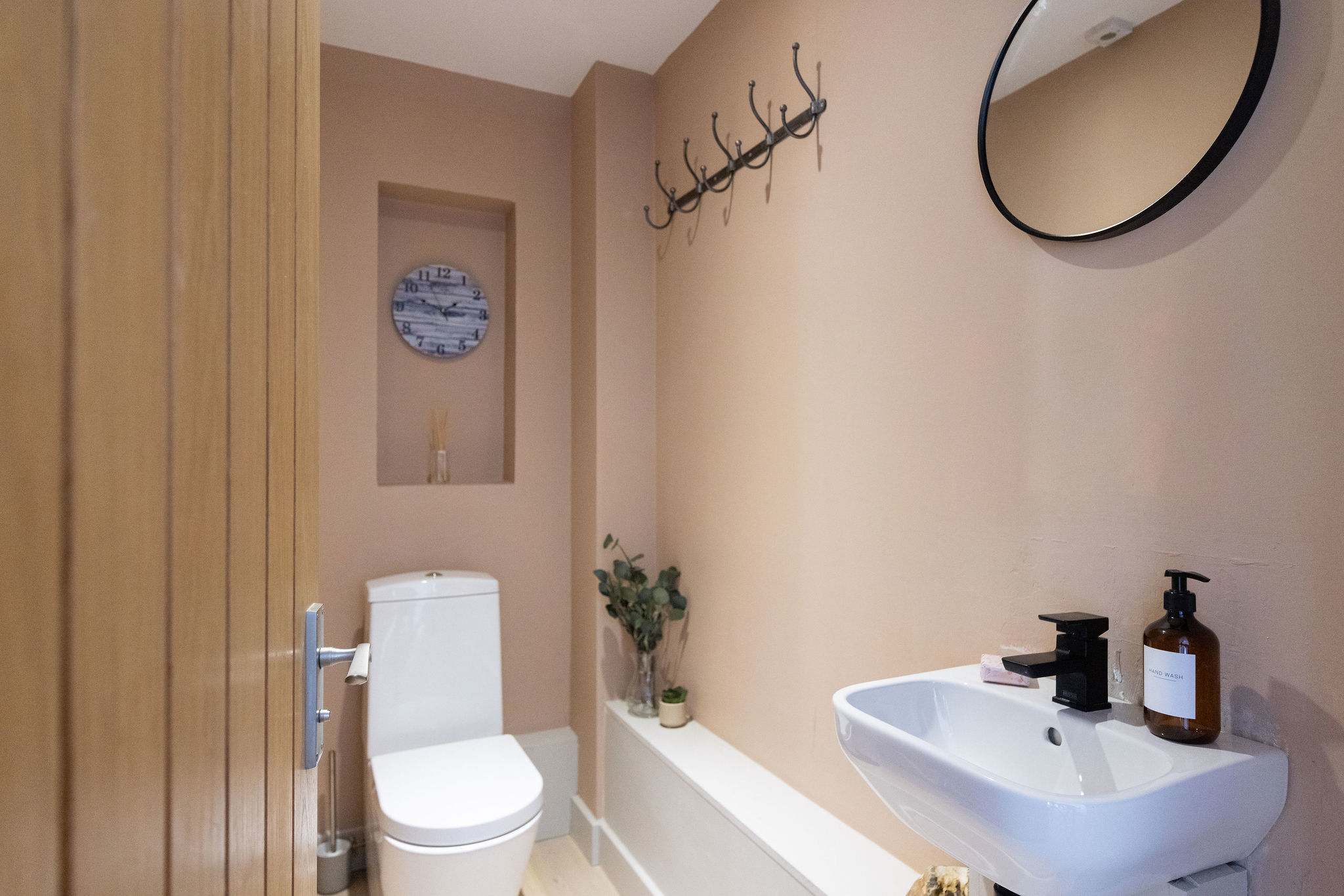A beautifully finished cloakroom with a fresh, modern feel and a stylish statement basin, adding a touch of luxury to the space.