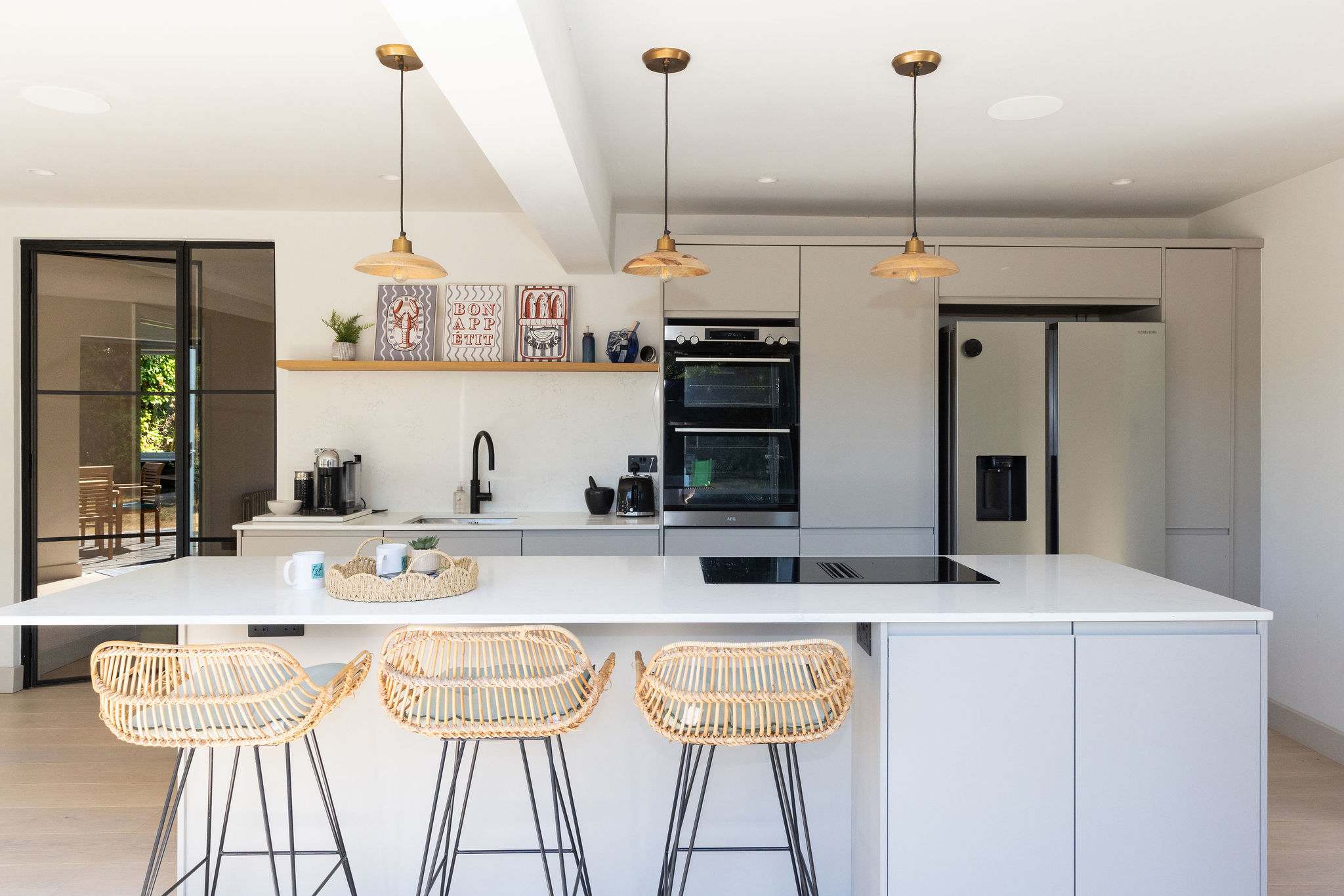 Airy, elegant and wonderfully spacious, this beautifully finished kitchen has a real sense of luxury, with a sleek white island, generous worktop space and a full range of appliances for effortless cooking and entertaining.