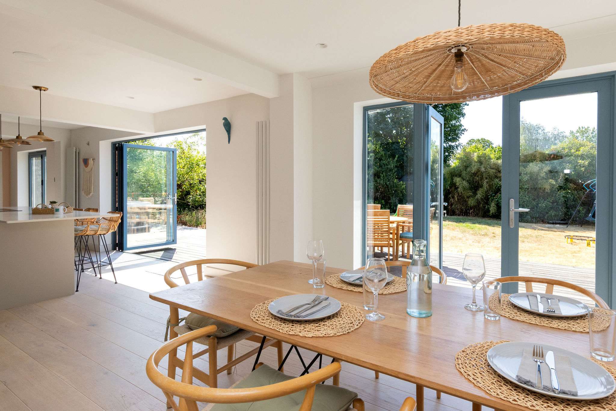 The dining area sits naturally alongside the kitchen, creating an open, sociable layout with bi-fold doors bringing in plenty of light and opening the whole space out to the garden.
