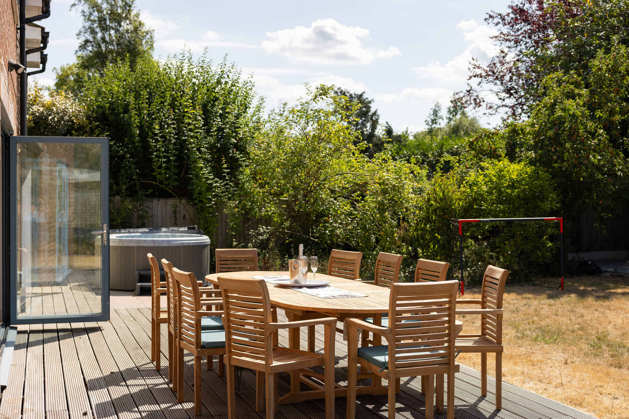A gorgeous outdoor dining space set on the decking just outside the kitchen, with seating for up to 10 guests — perfect for long summer lunches, relaxed evening meals and drinks together, with the hot tub right alongside.