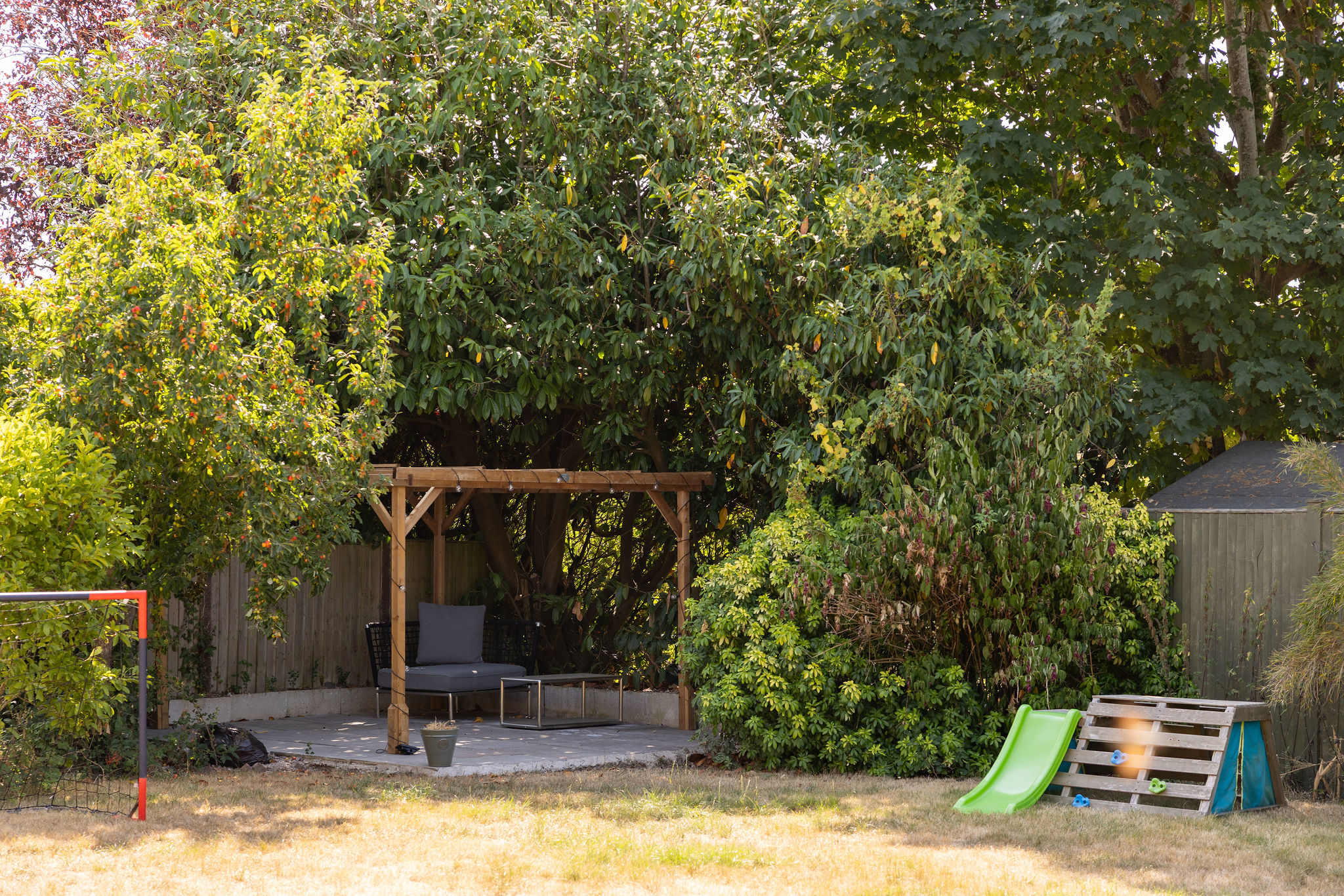 Tucked away at the bottom of the garden, this charming patio offers a peaceful spot to sit and unwind, with comfortable seating and soft lighting creating a lovely atmosphere as the day draws in.