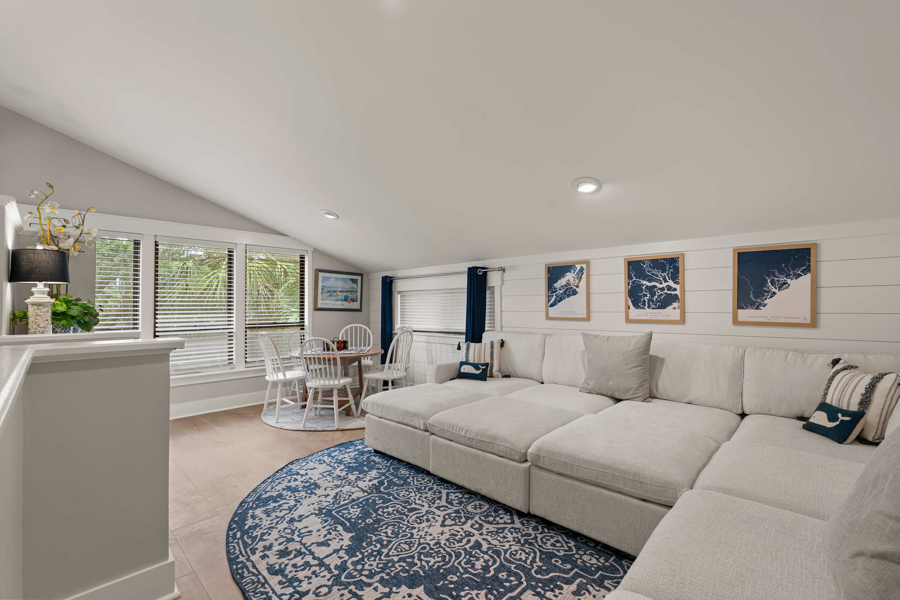 1st level den with sectional couch, table and chairs and tv
