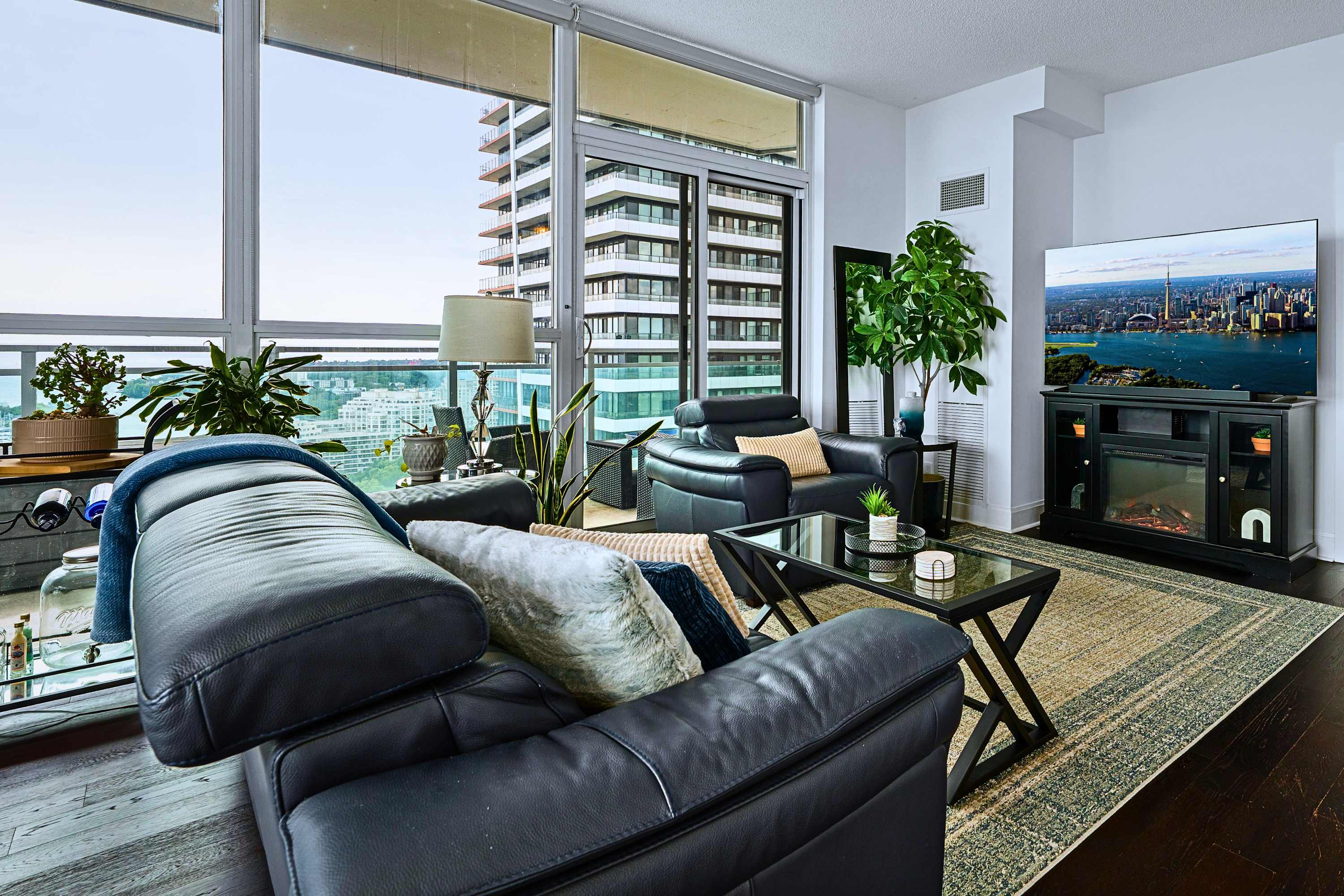 Living room with balcony access and city views, a comfortable home base for your extended stay.