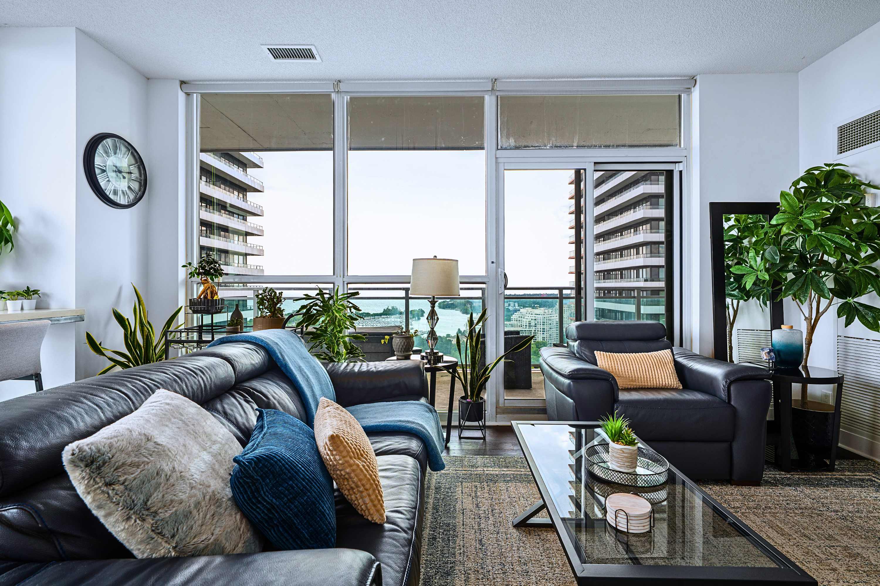 Living room with direct balcony access and scenic city views for guests.
