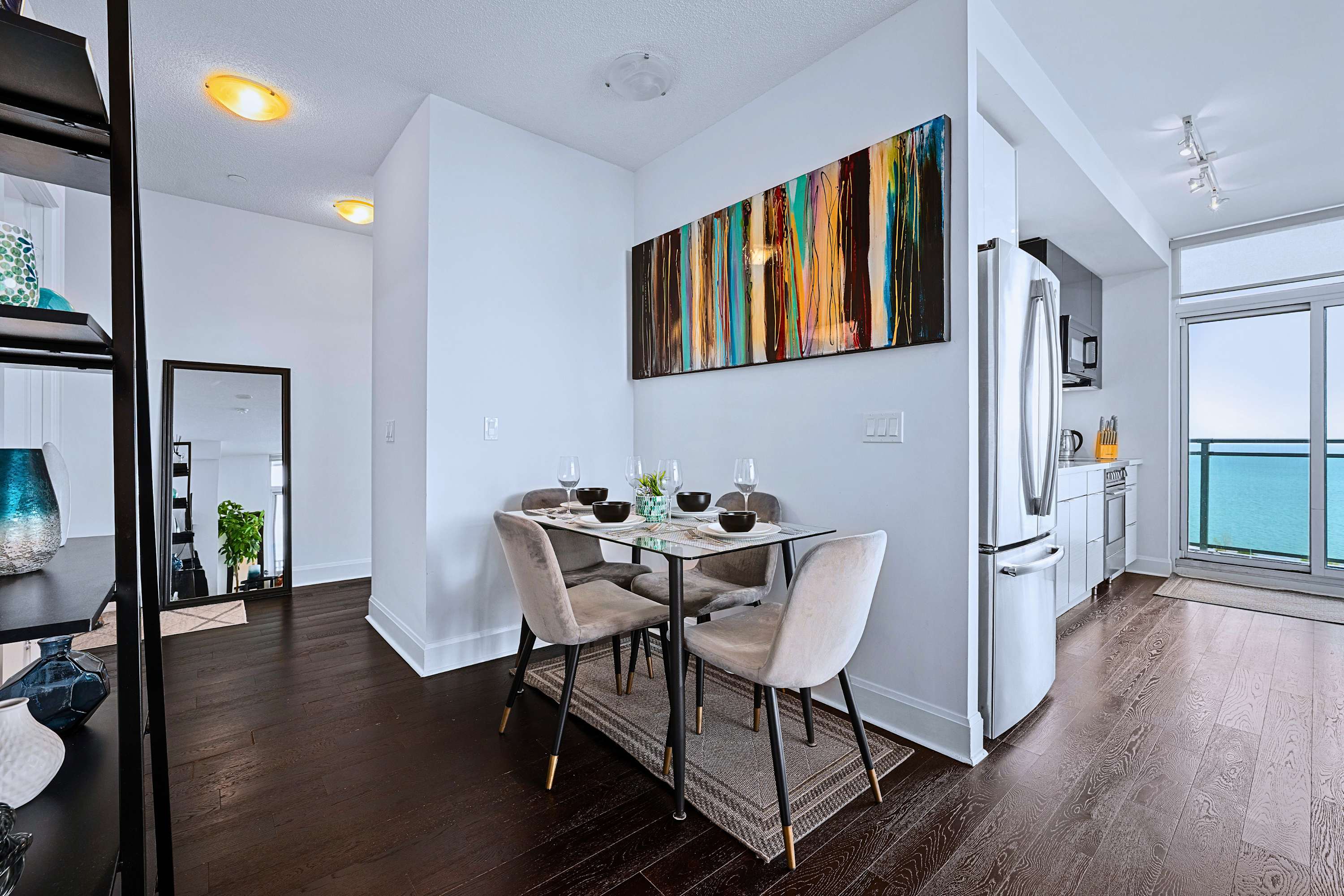 Table set for four positioned between the living area and open kitchen.