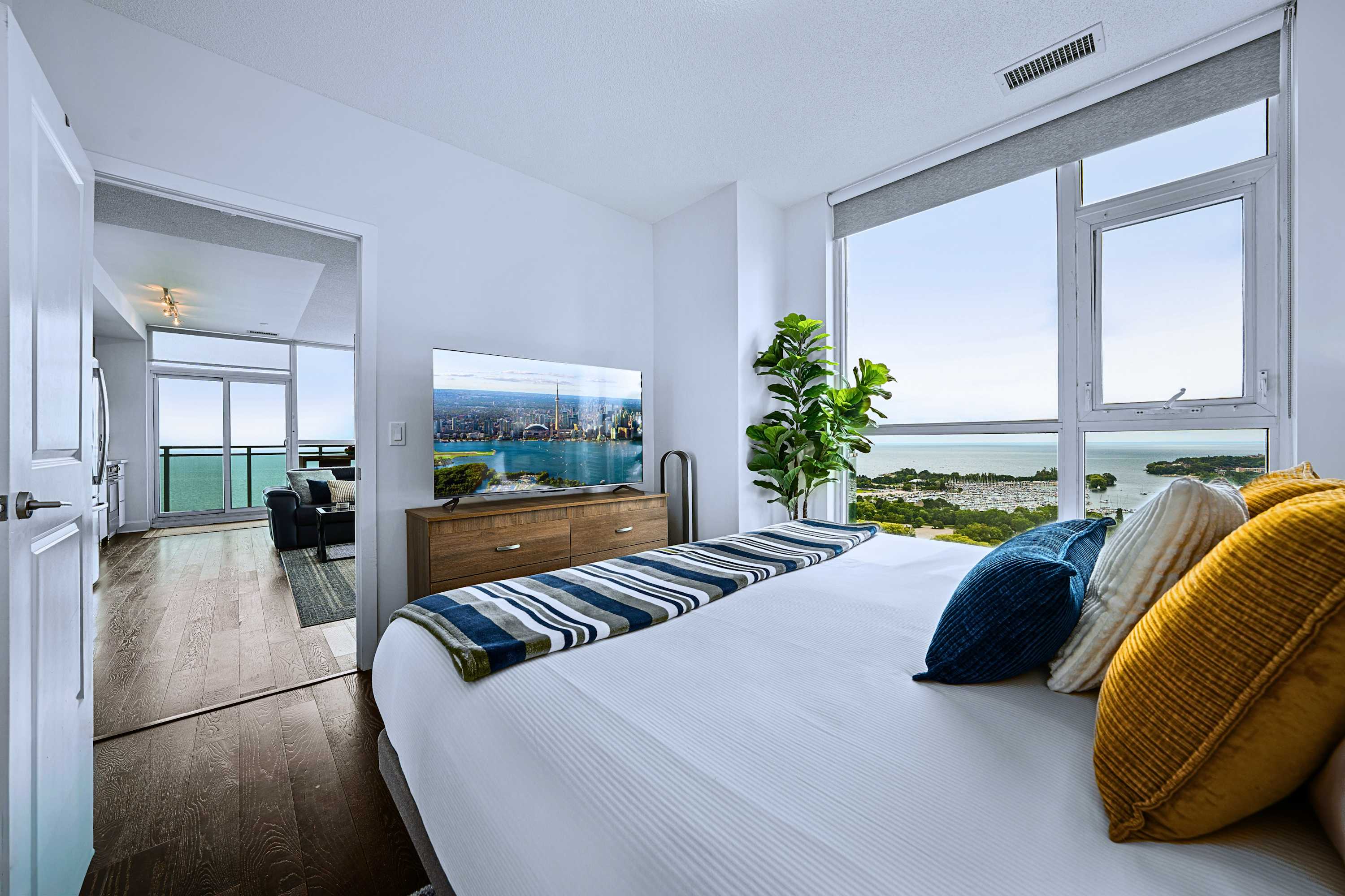 King bedroom with smart TV and clear, impressive city views from the bed.