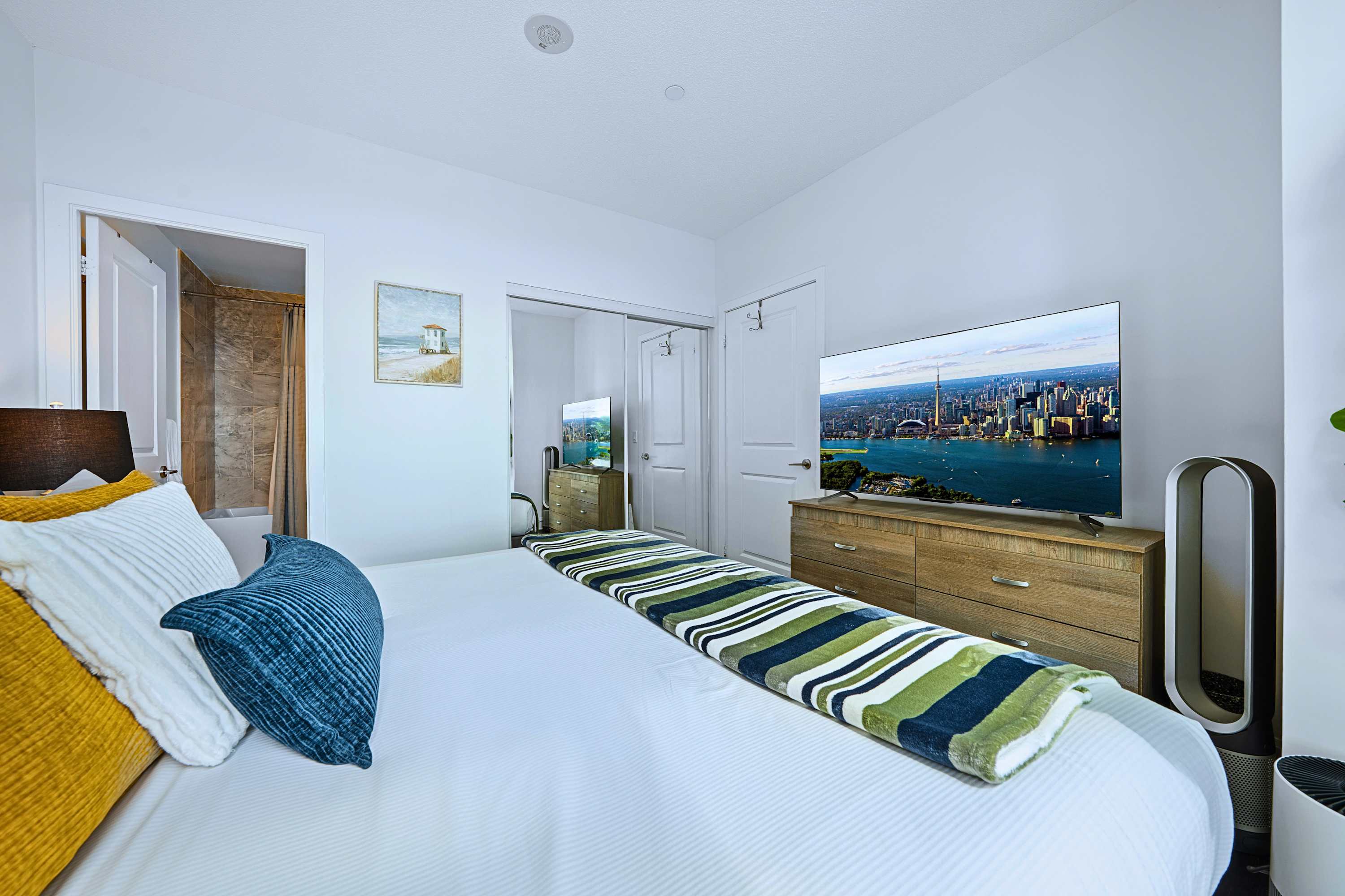Spacious king bedroom with flat-screen TV and direct ensuite bathroom access.