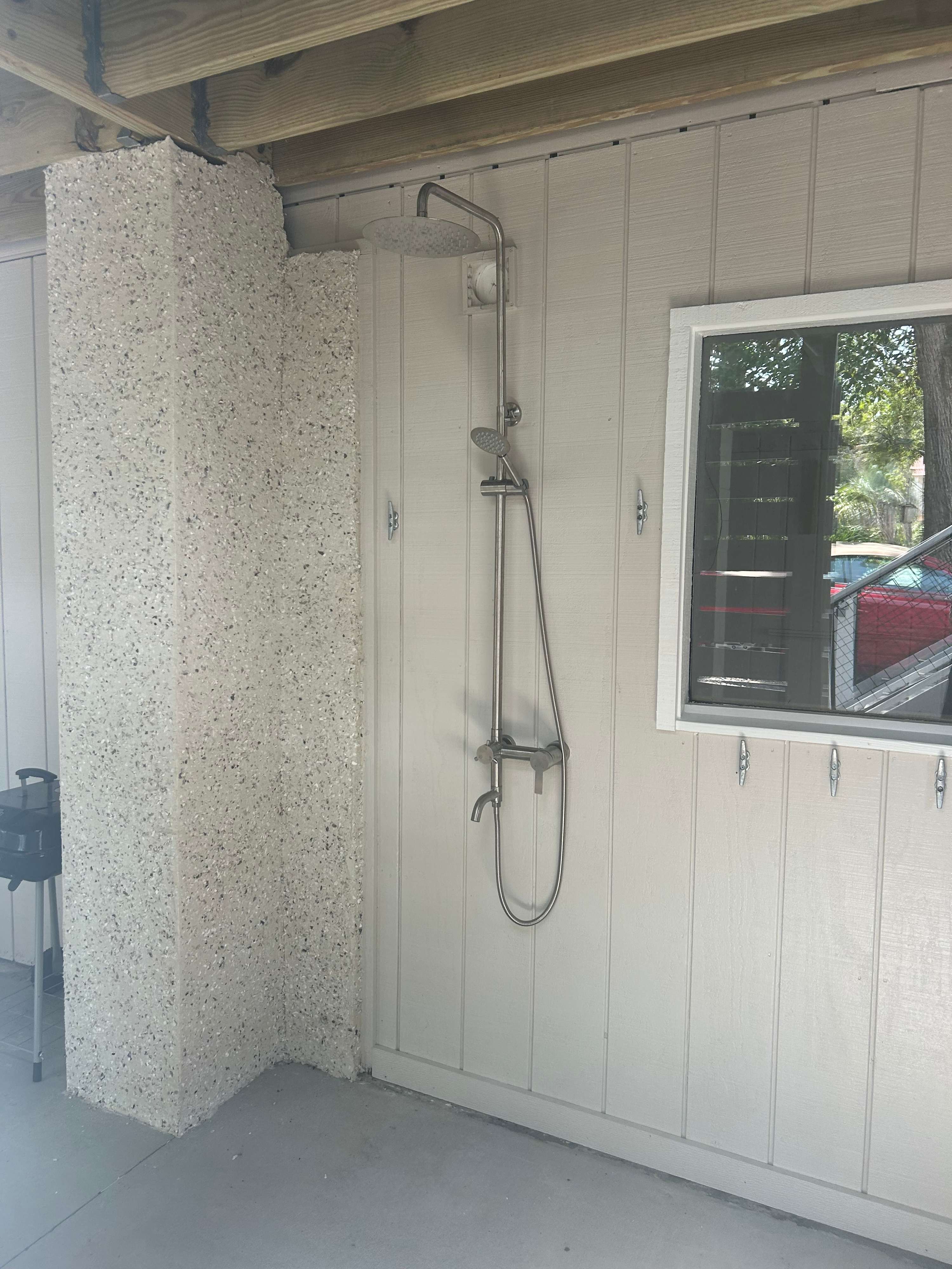 Outdoor shower behind front stairs