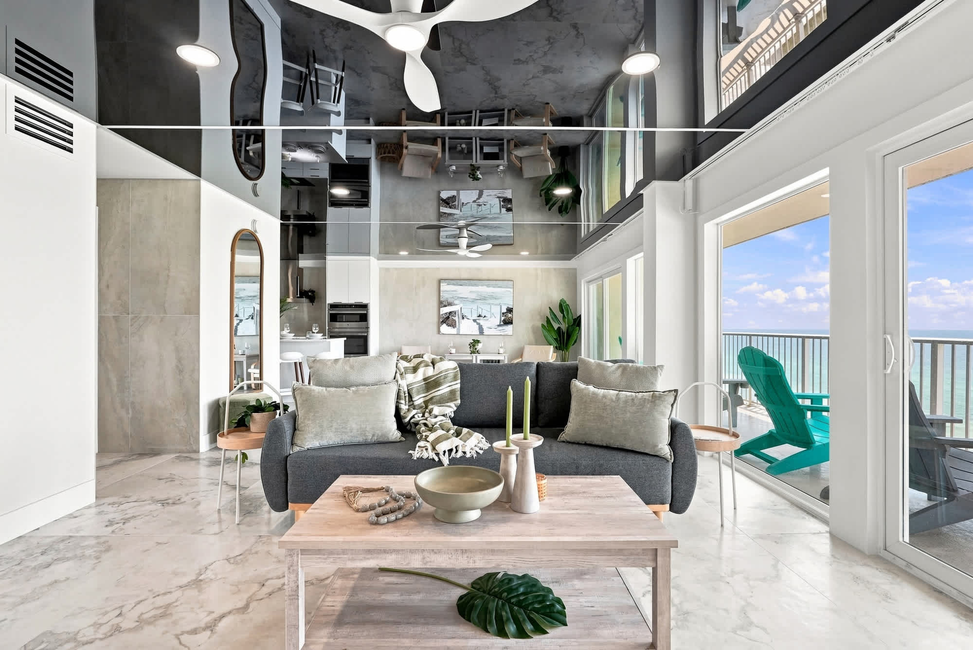 The Summit 1512 – Modern living room with gray sofa, wooden table, large windows, and ocean view balcony.