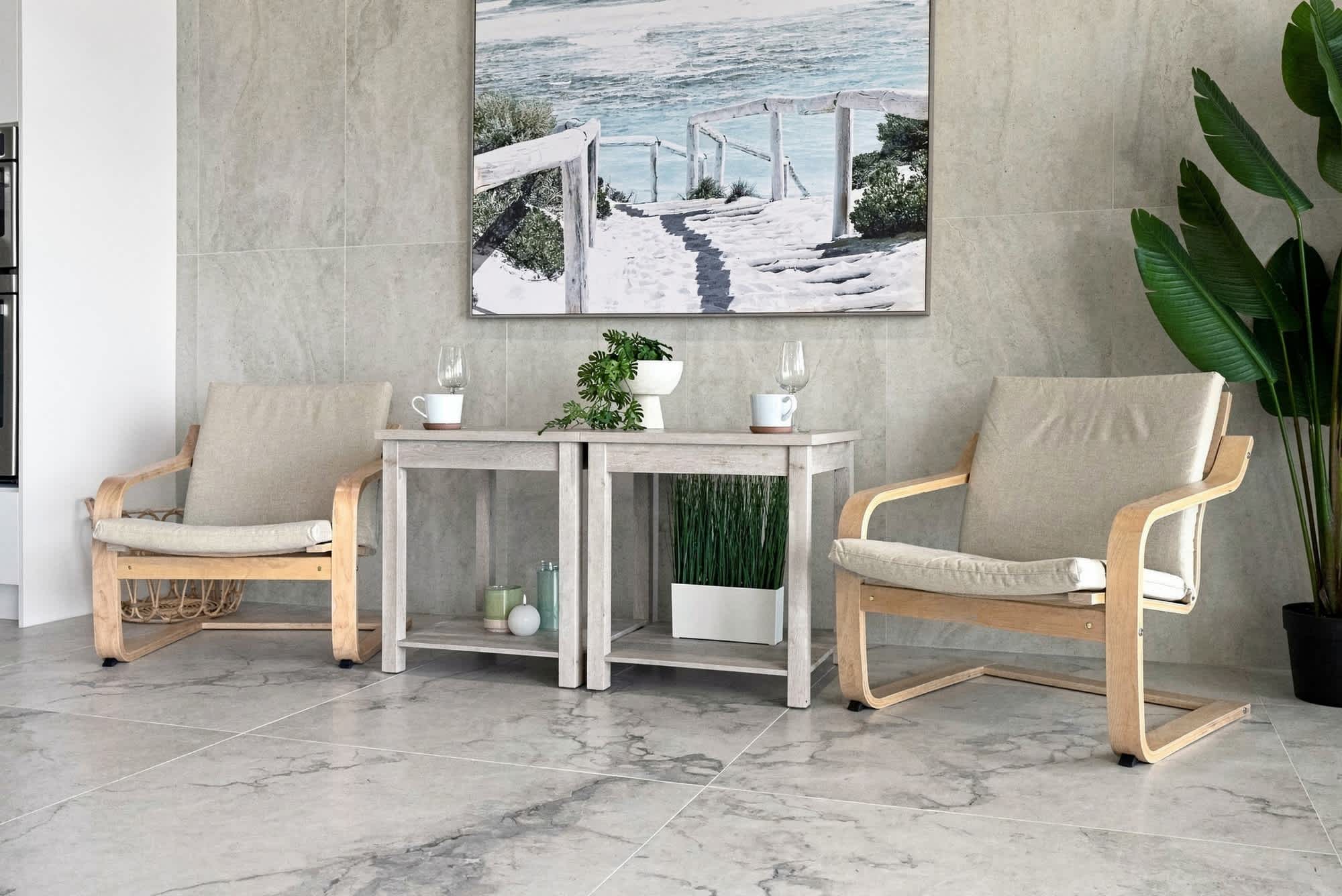 The Summit 1512 – Interior seating area with two chairs, small table, decorative plant, and coastal artwork.