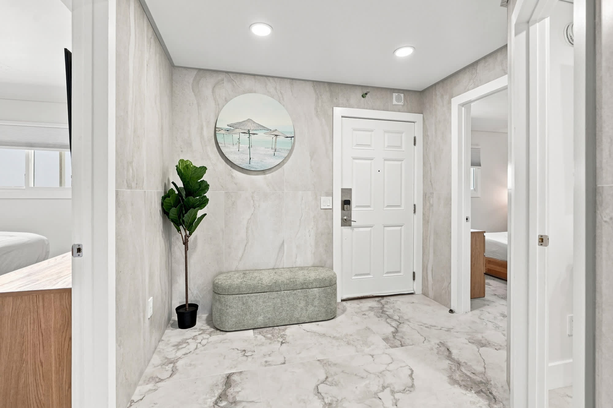 The Summit 1512 – Entrance hallway with marble floor, potted plant, and decorative wall art.