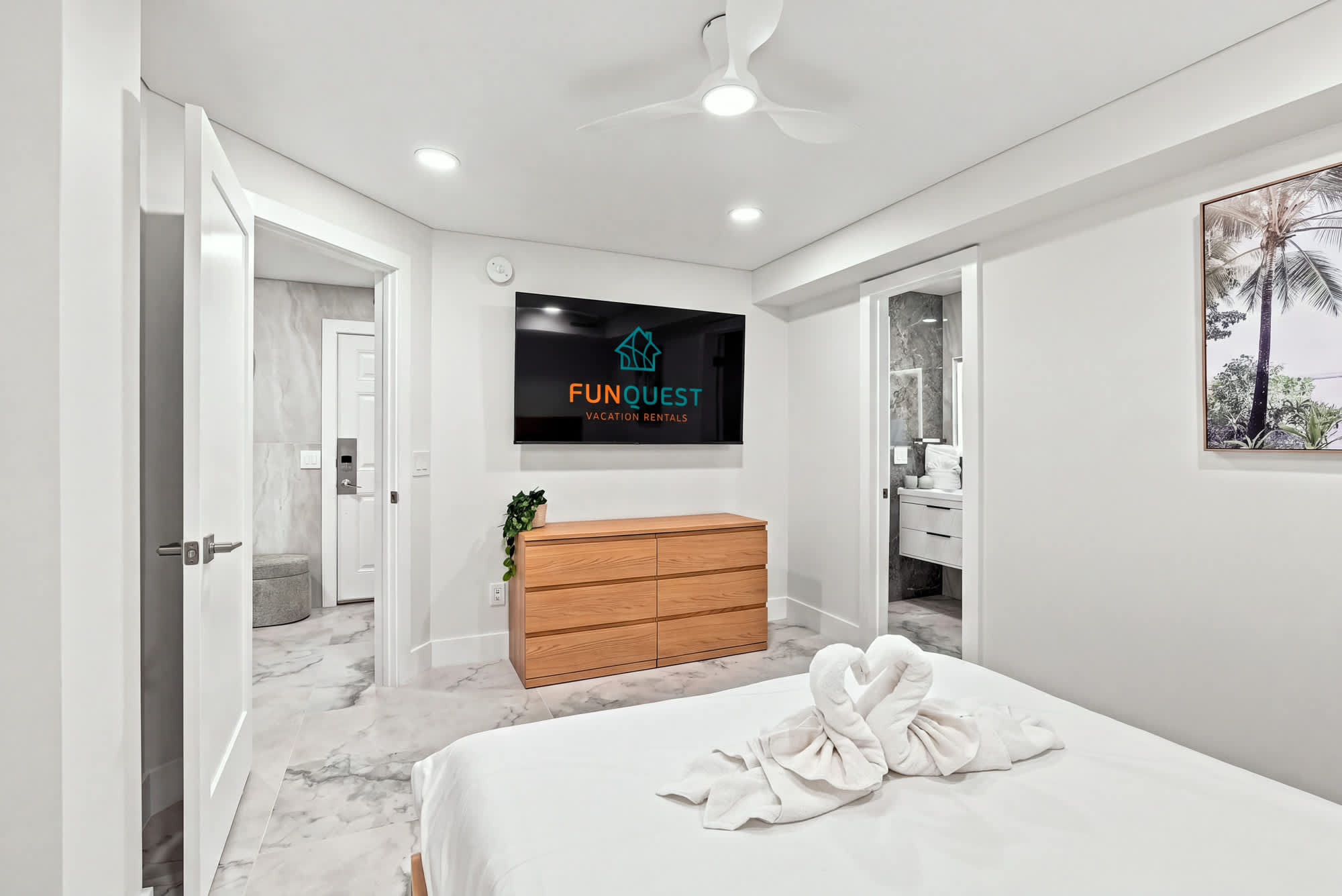 The Summit 1512 – Modern bedroom with queen bed, TV, dresser, and adjoining bathroom access.